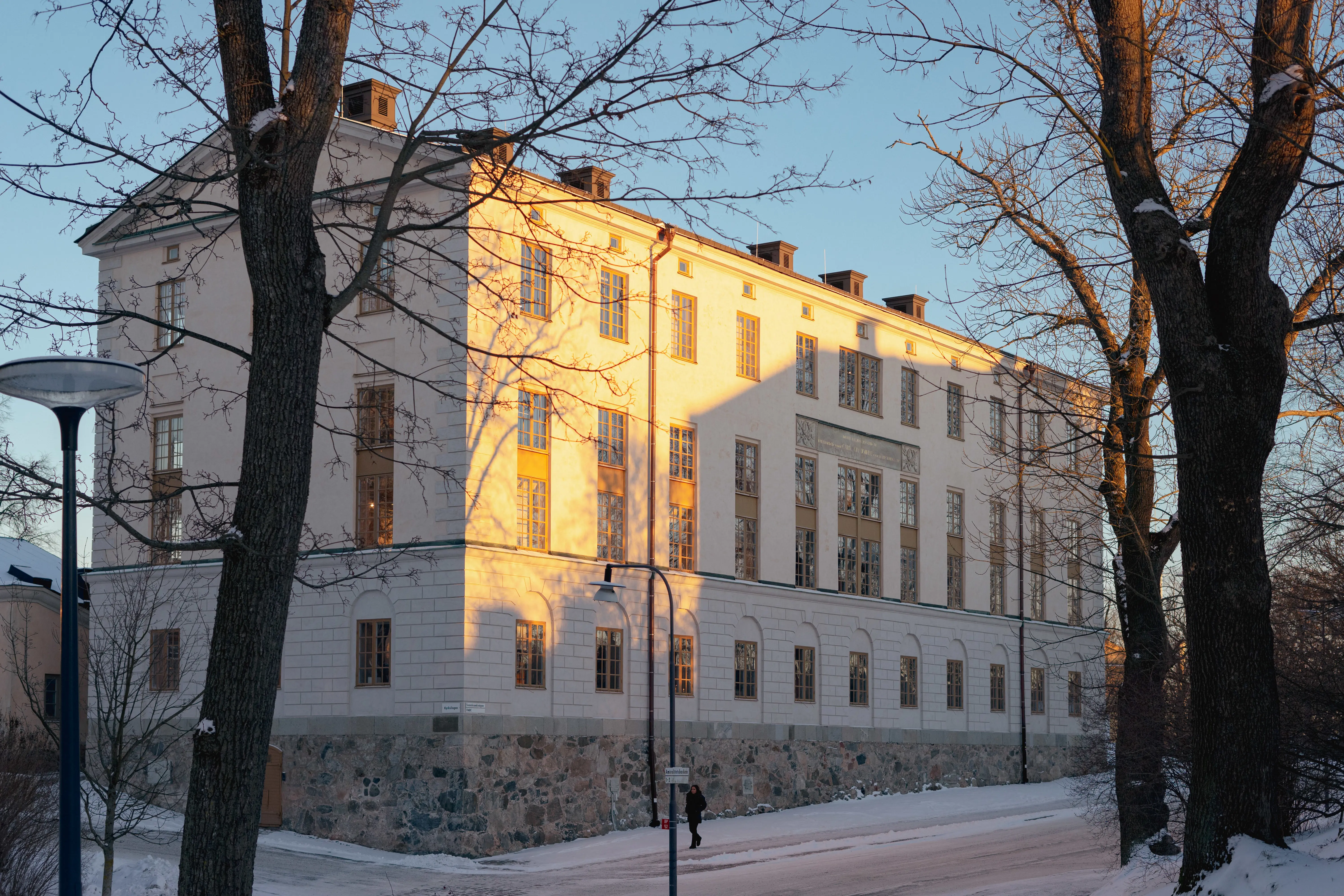 Kasern två efter renovering. En vitputsad, avlång byggnad med stensockel. Vinter och snö.