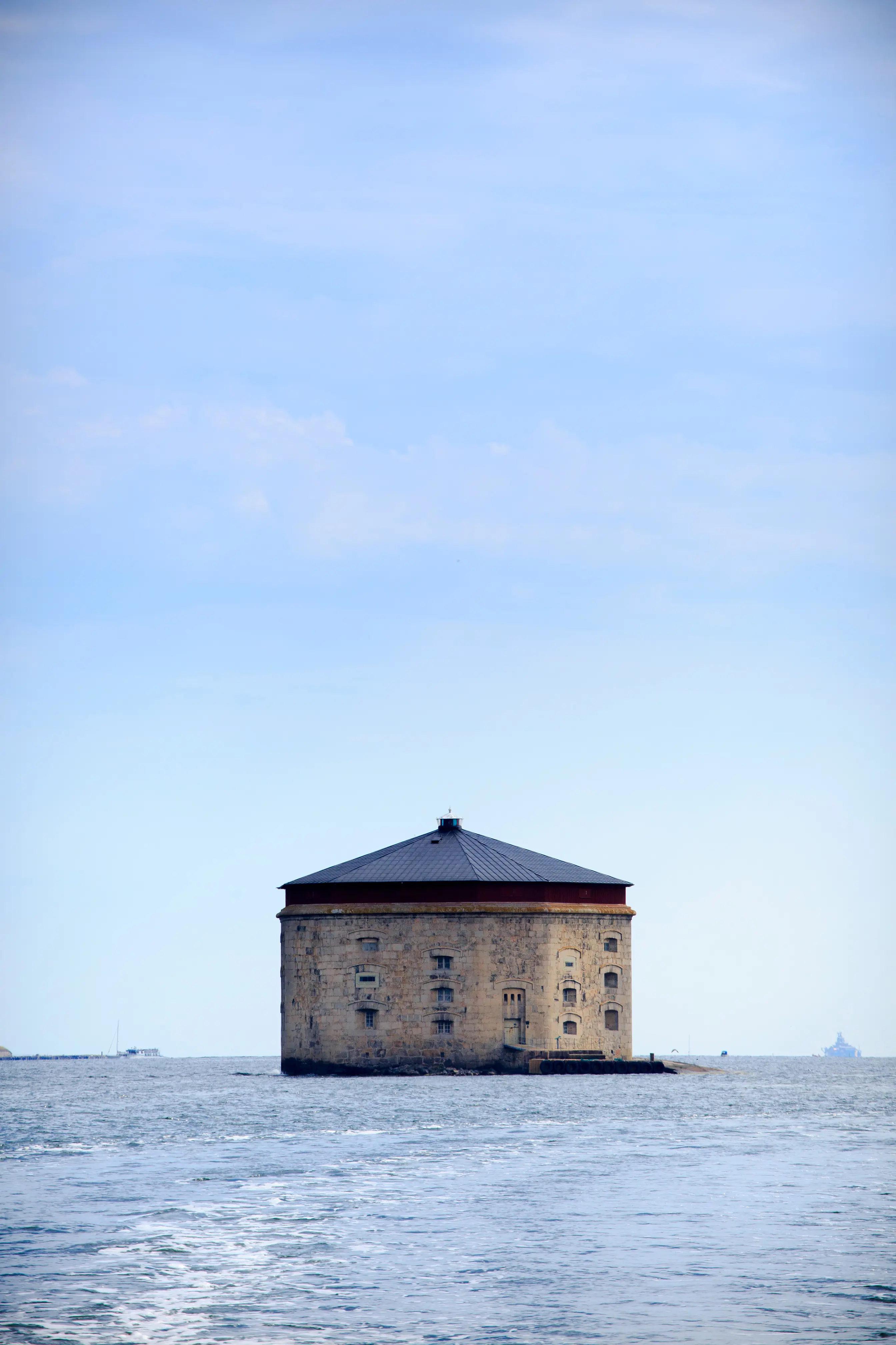 Stenhus med toppigt tak mitt ute i havet.