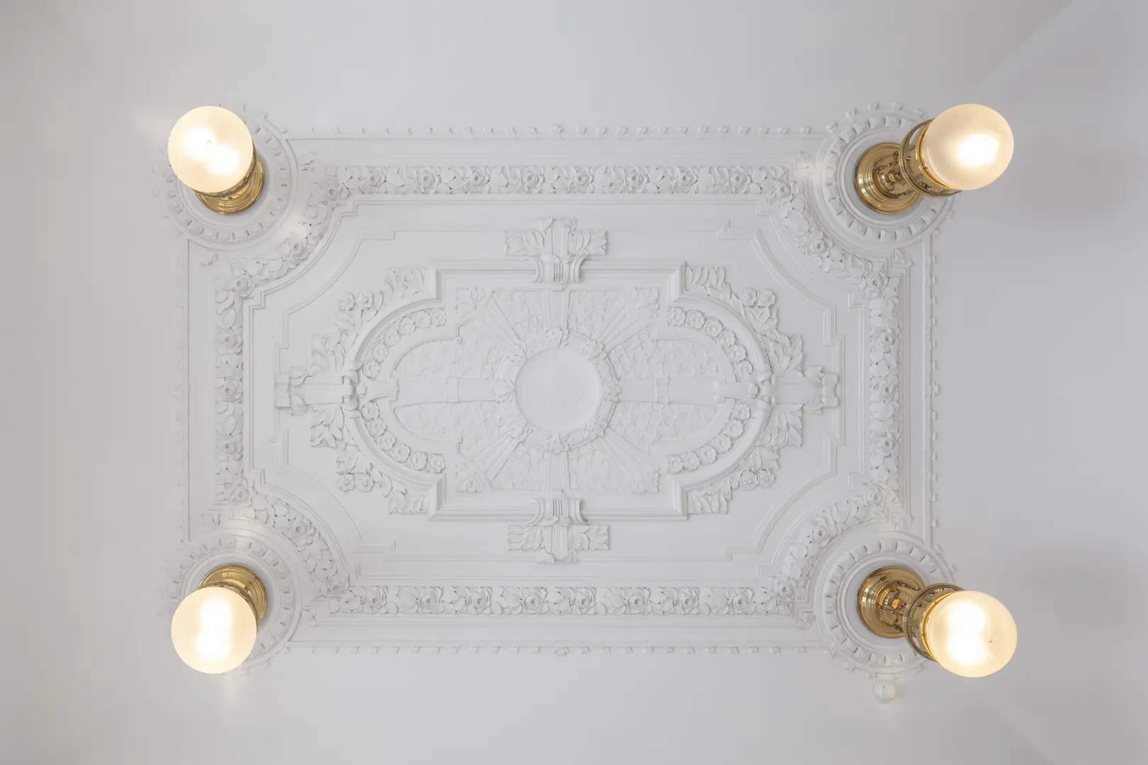 Stuckatur med runda lampor i varje hörn.