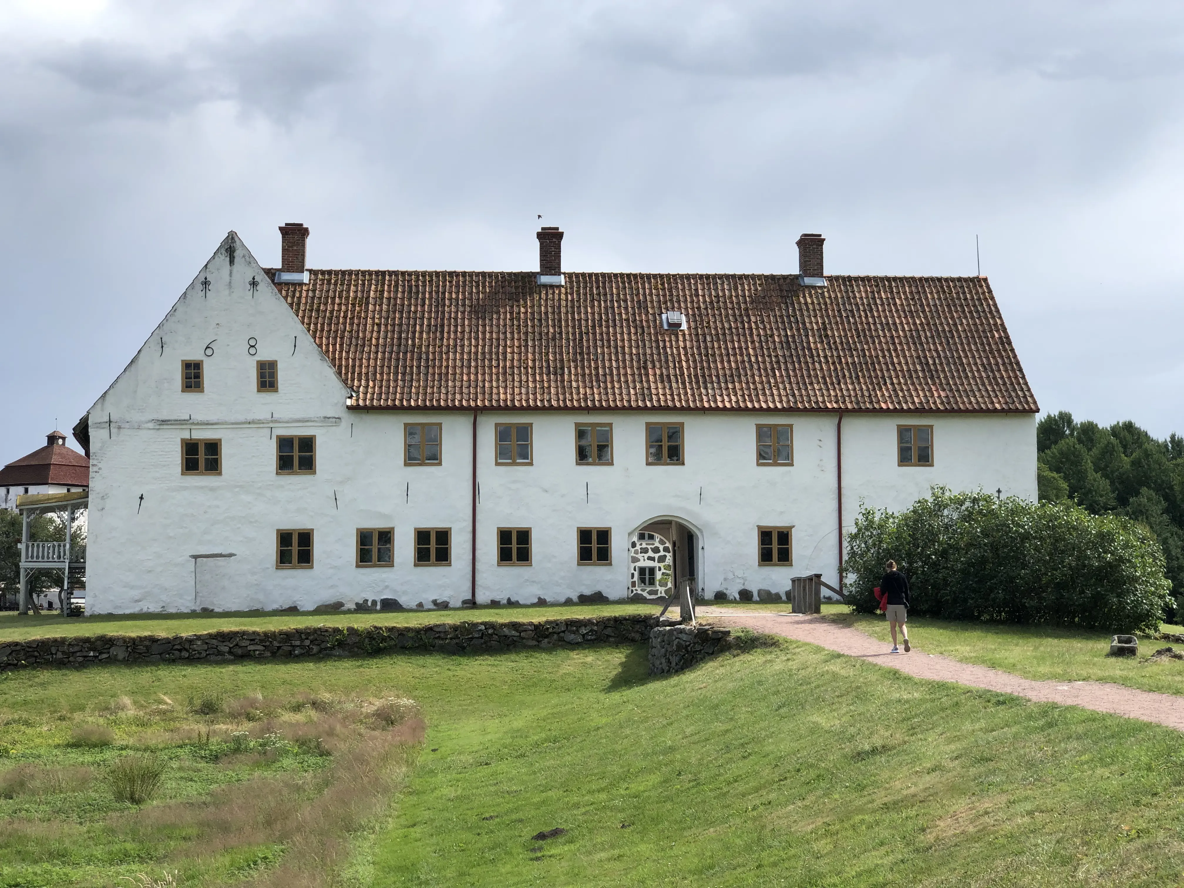 Hovdala slott. En vitputsad stenbyggnad med synliga ankarslut och brant tegeltak. Fyra av ankarsluten bildar årtalet sextonhundraåttioett.