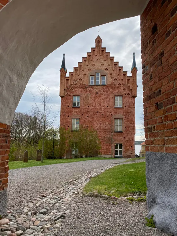 Utsikt mot Roggeborgen från ett valv där en grusväg breder ut sig fram till byggnaden.