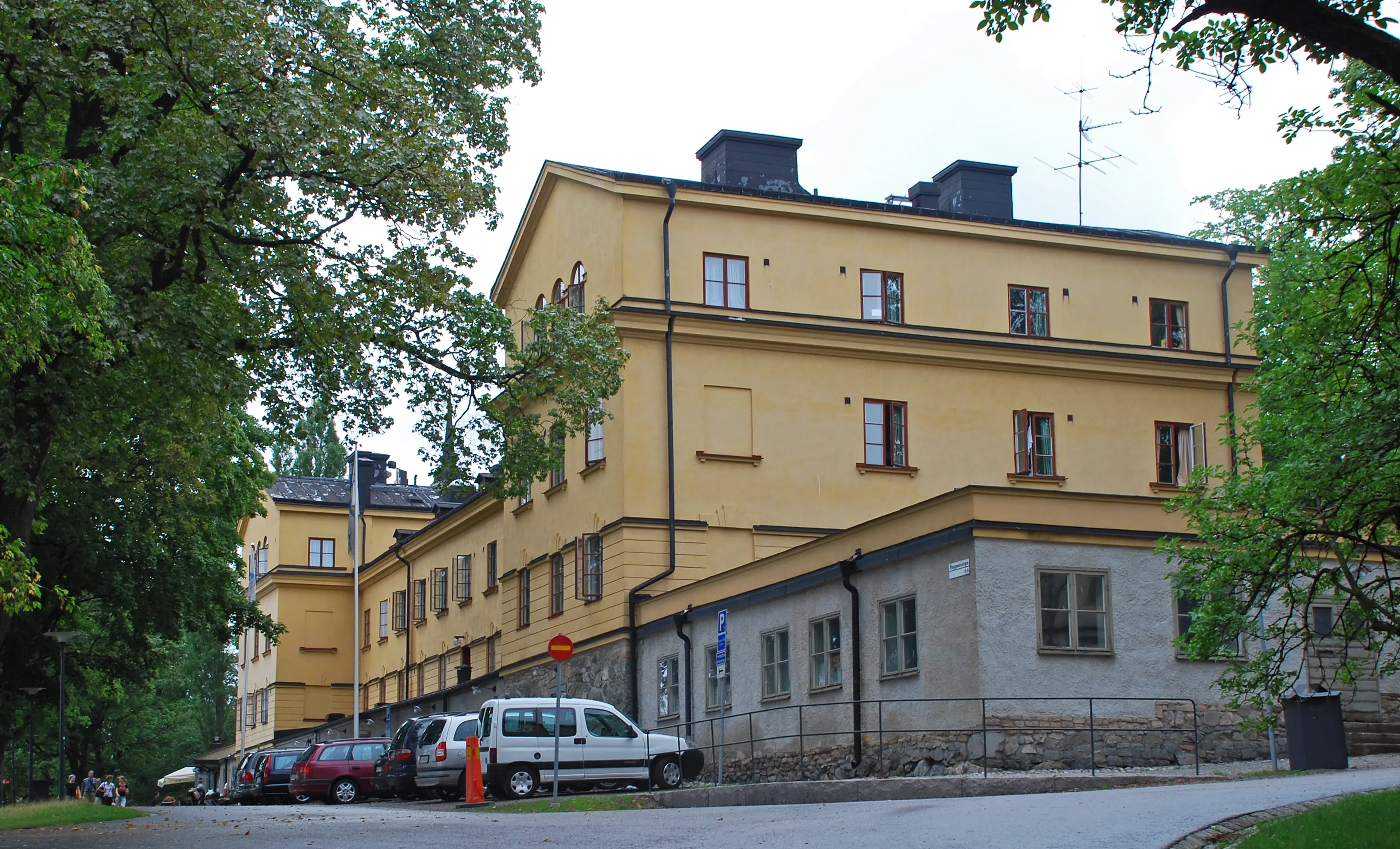 Hantverkskasernen på Skeppsholmen. En gulputsad klassicistisk byggnad i två våningar, med flyglar som är en våning högre.