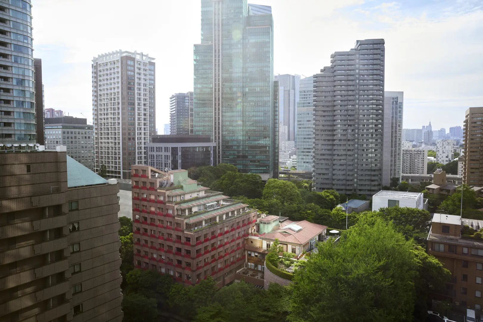 Ambassadbyggnaden omgärdad av grönska med skyskrapor runtomkring