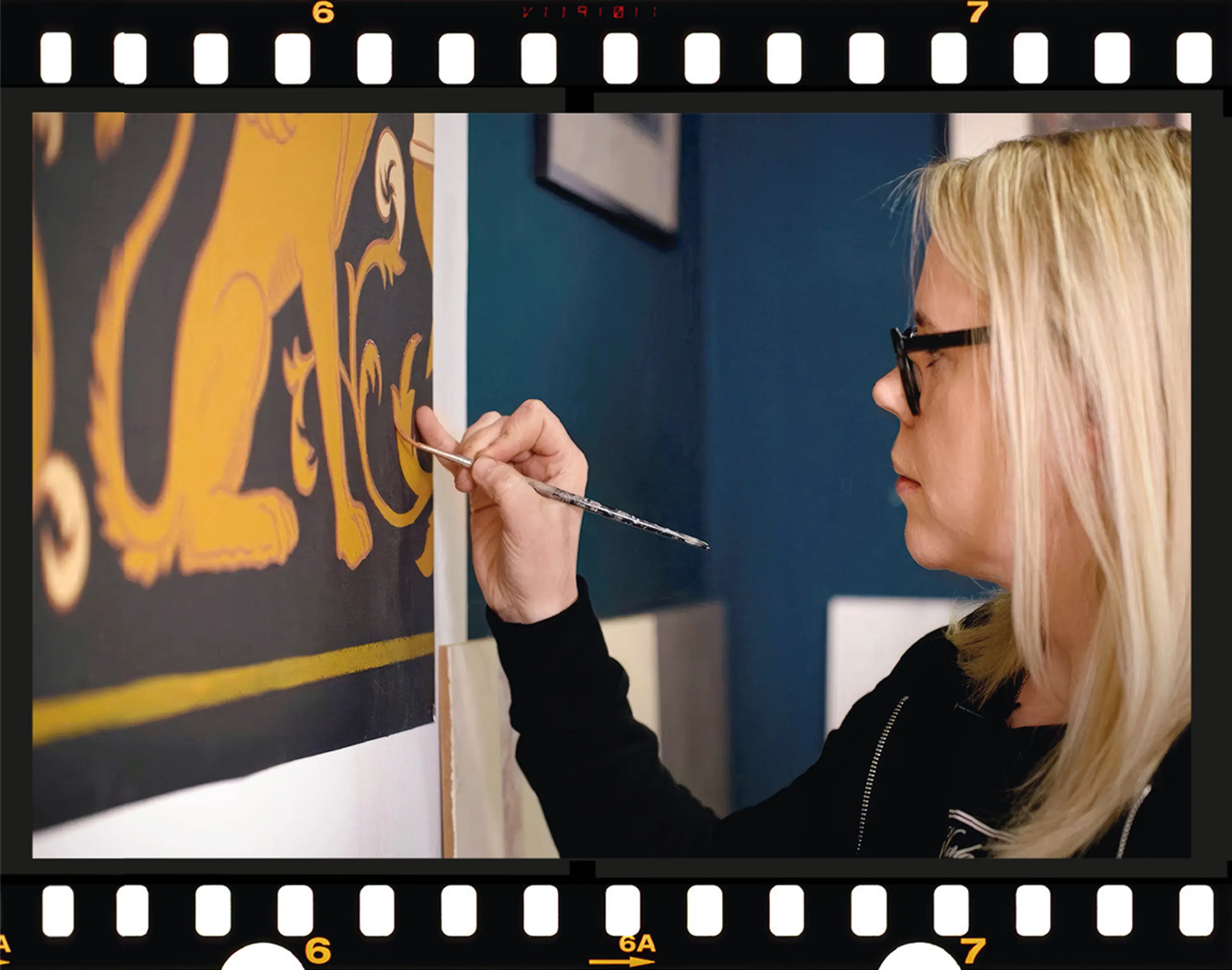 Filmruta med dekormålare som penselmålar mönster på en målning.