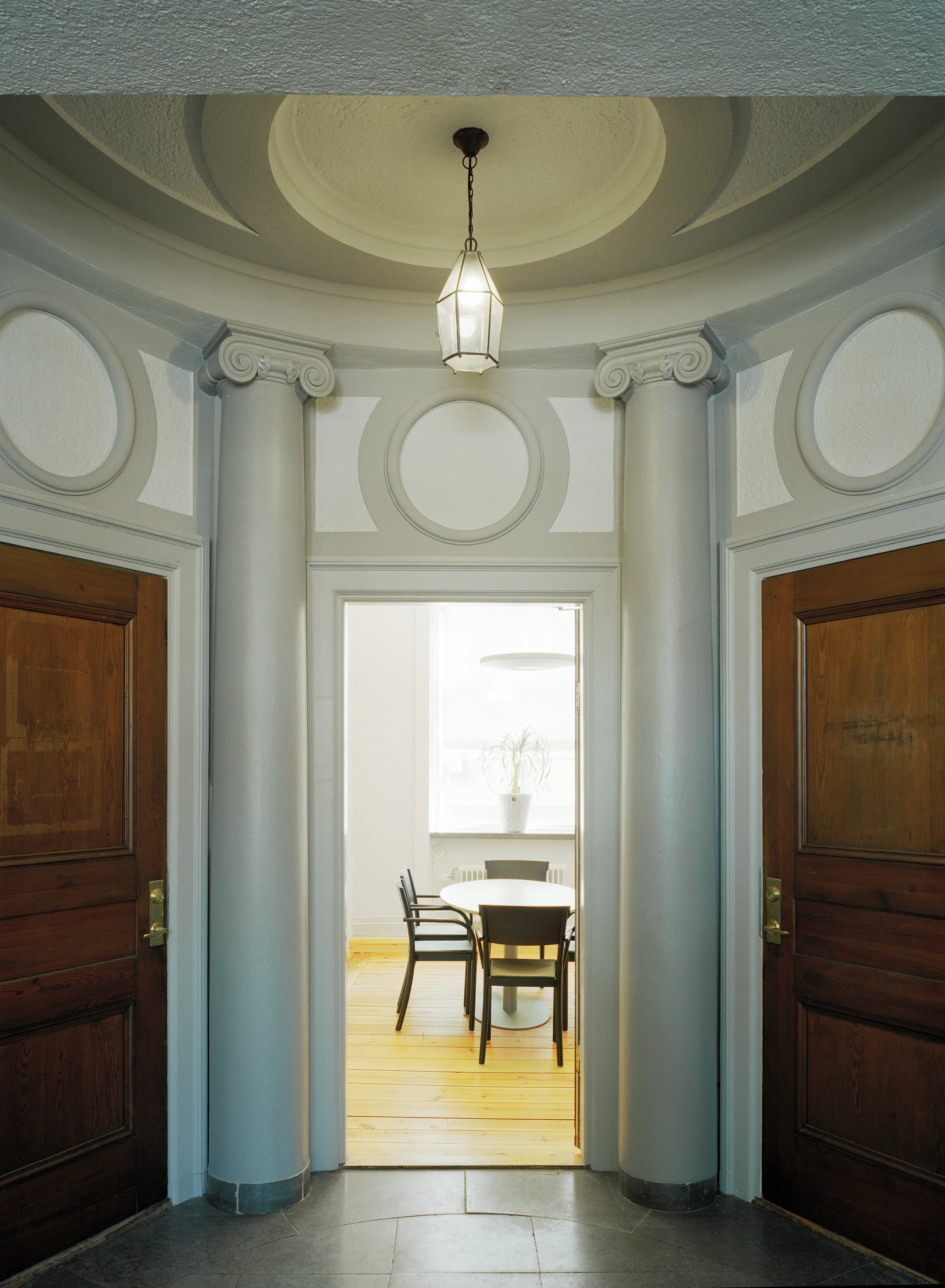 Interiör, Ekermanska huset. Rund hall med stengolv och klassicistisk dekor. En öppen dörr leder till ett enkelt möblerat rum.