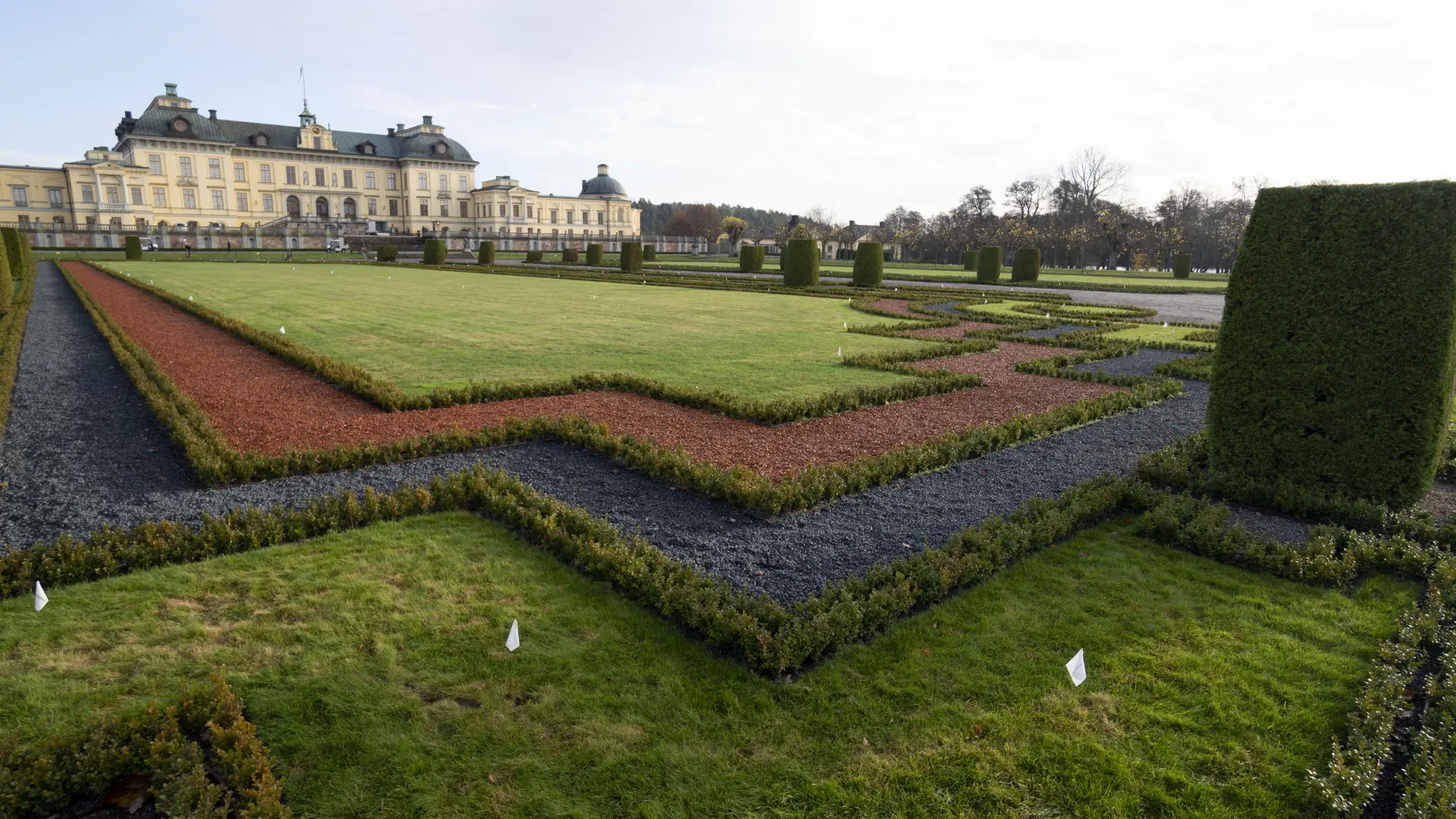 Framför Drottningholms slott avgränsas en gräsyta från en grusgång med smala strängar av buxbom.