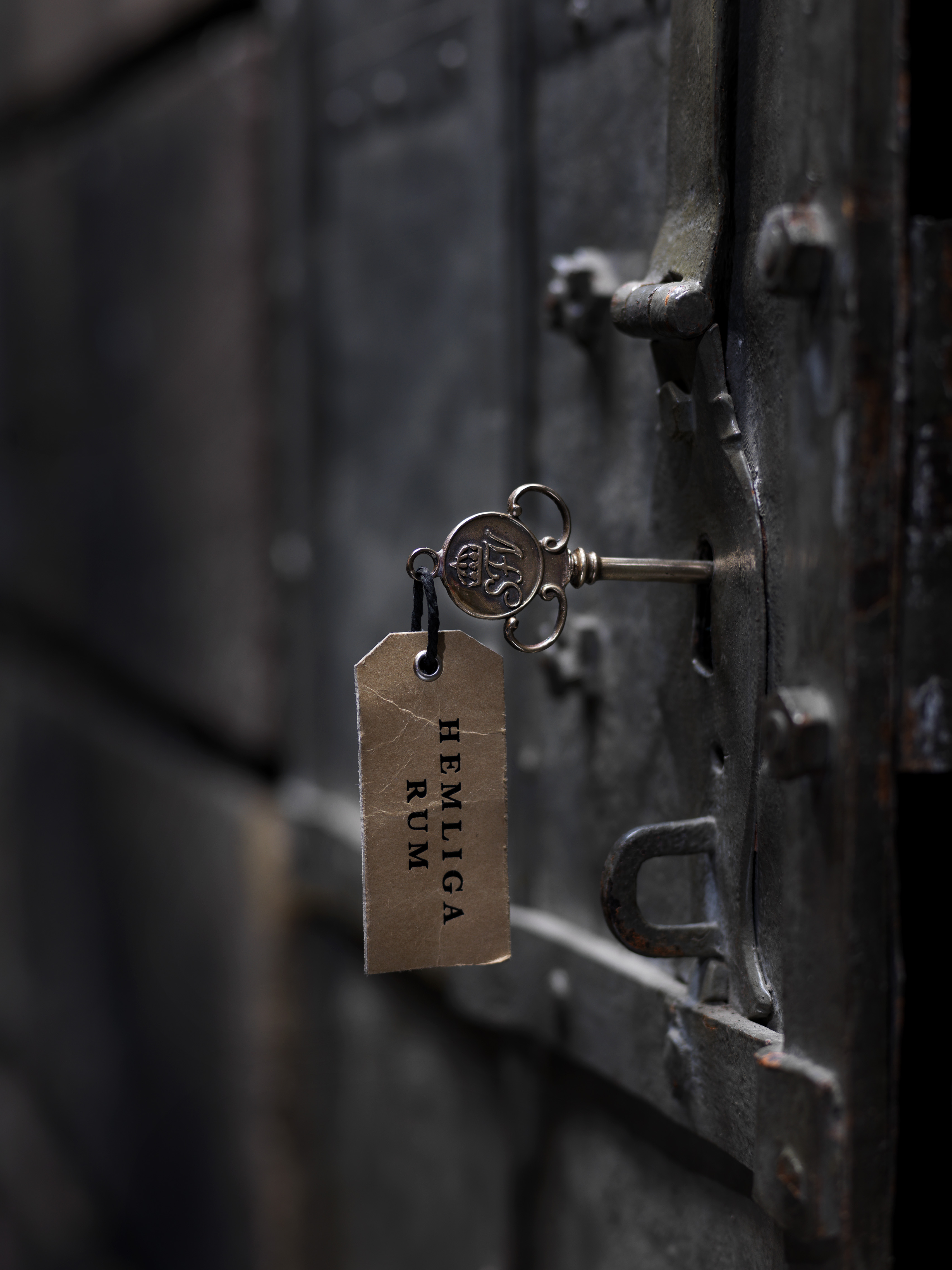 Hemliga rums nykel sitter i låset på en gammal järnport.