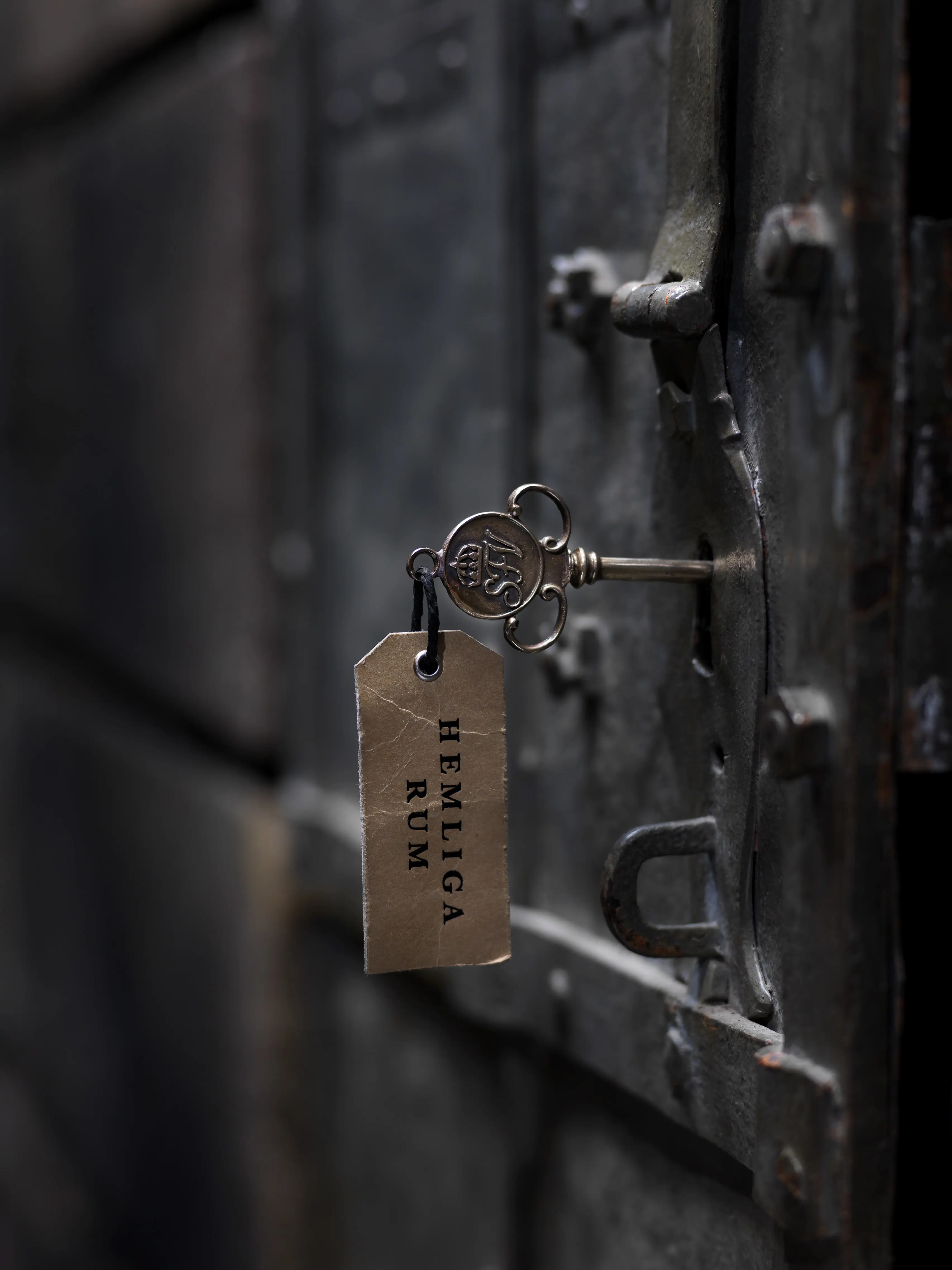 Hemliga rums nykel sitter i låset på en gammal järnport.