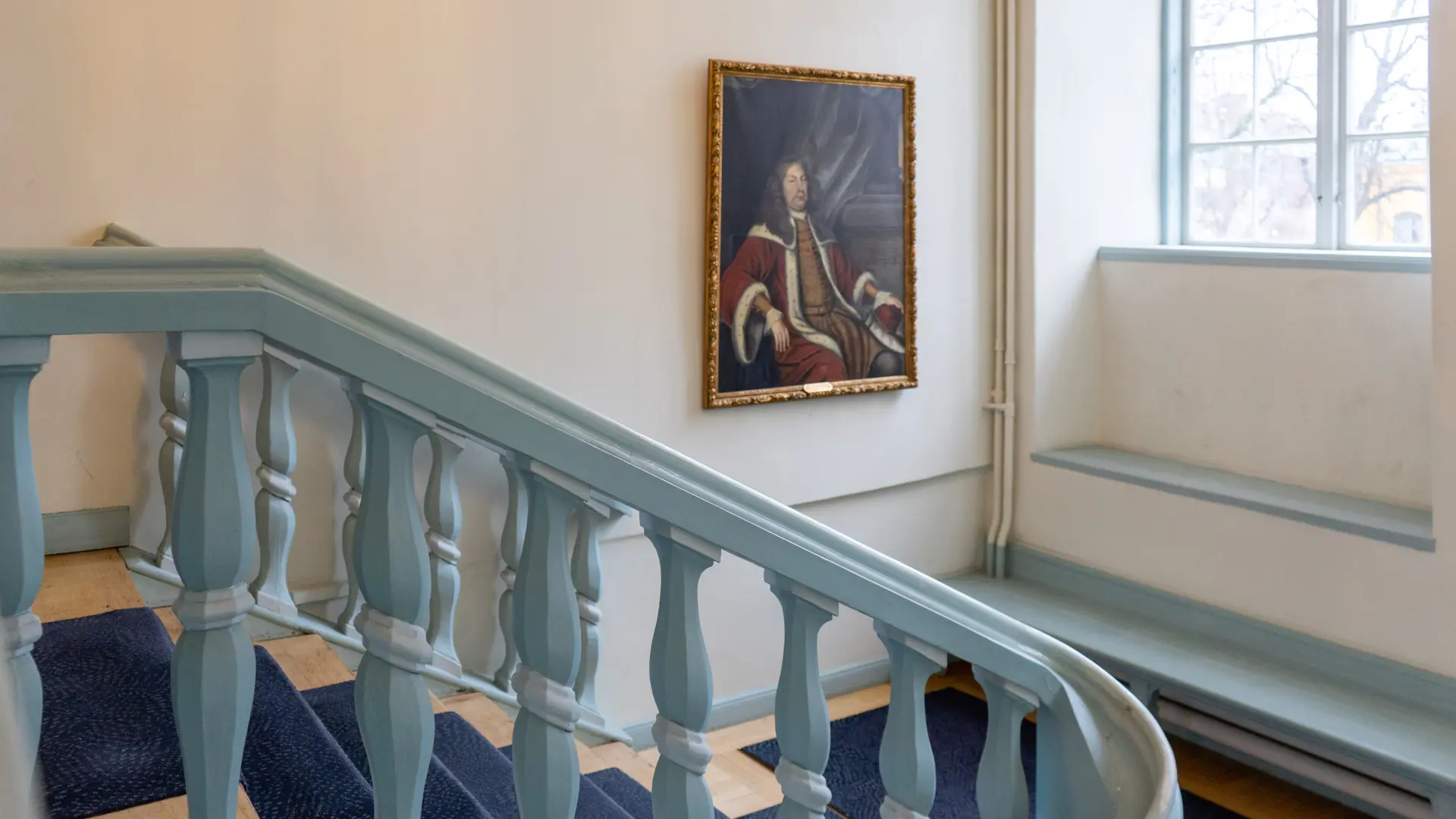 Trappa i domstolsbyggnaden med en inramad målning.