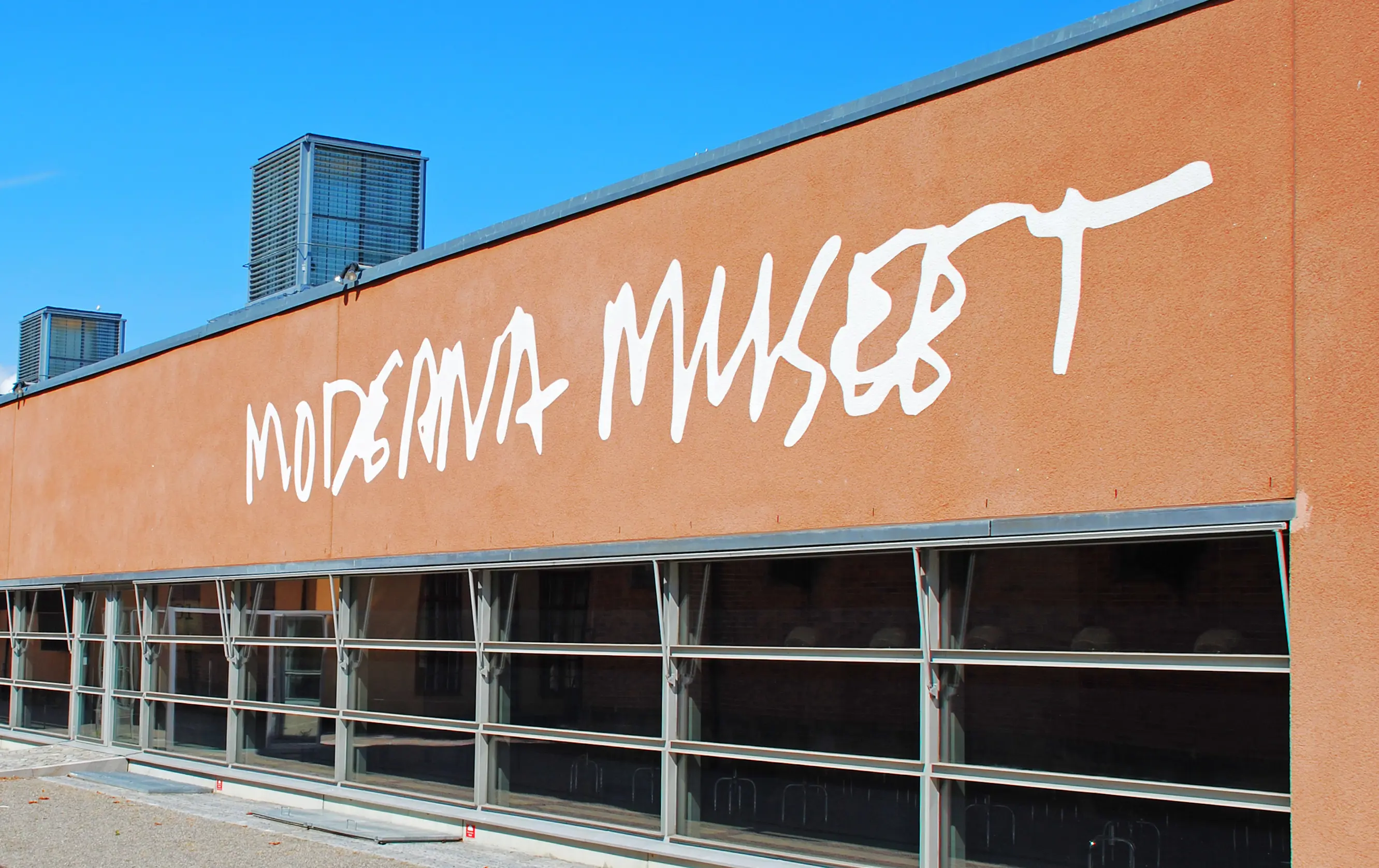 Moderna museet på Skeppsholmen. Detalj av entré-fasaden, med namnet "Moderna museet" målat i vitt ovanför fönster-raden