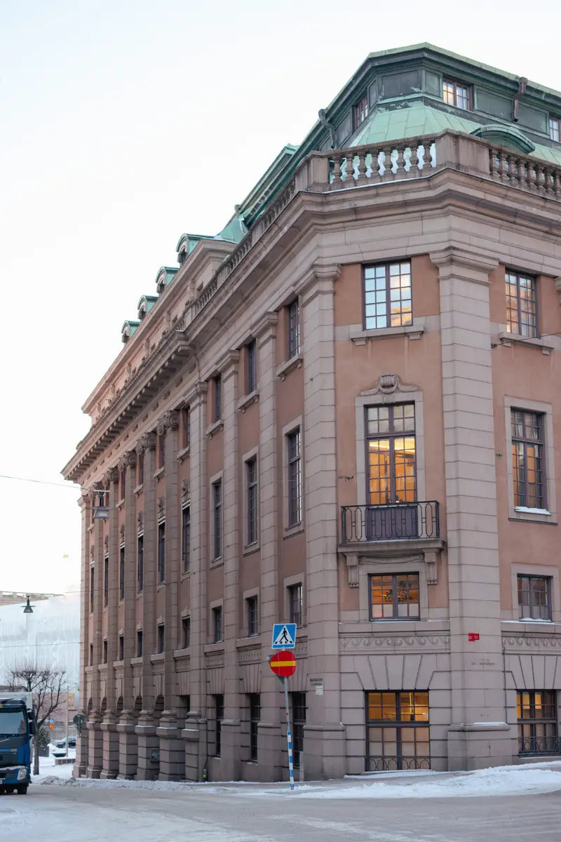 Fasad med brun puts och grå stenpartier.