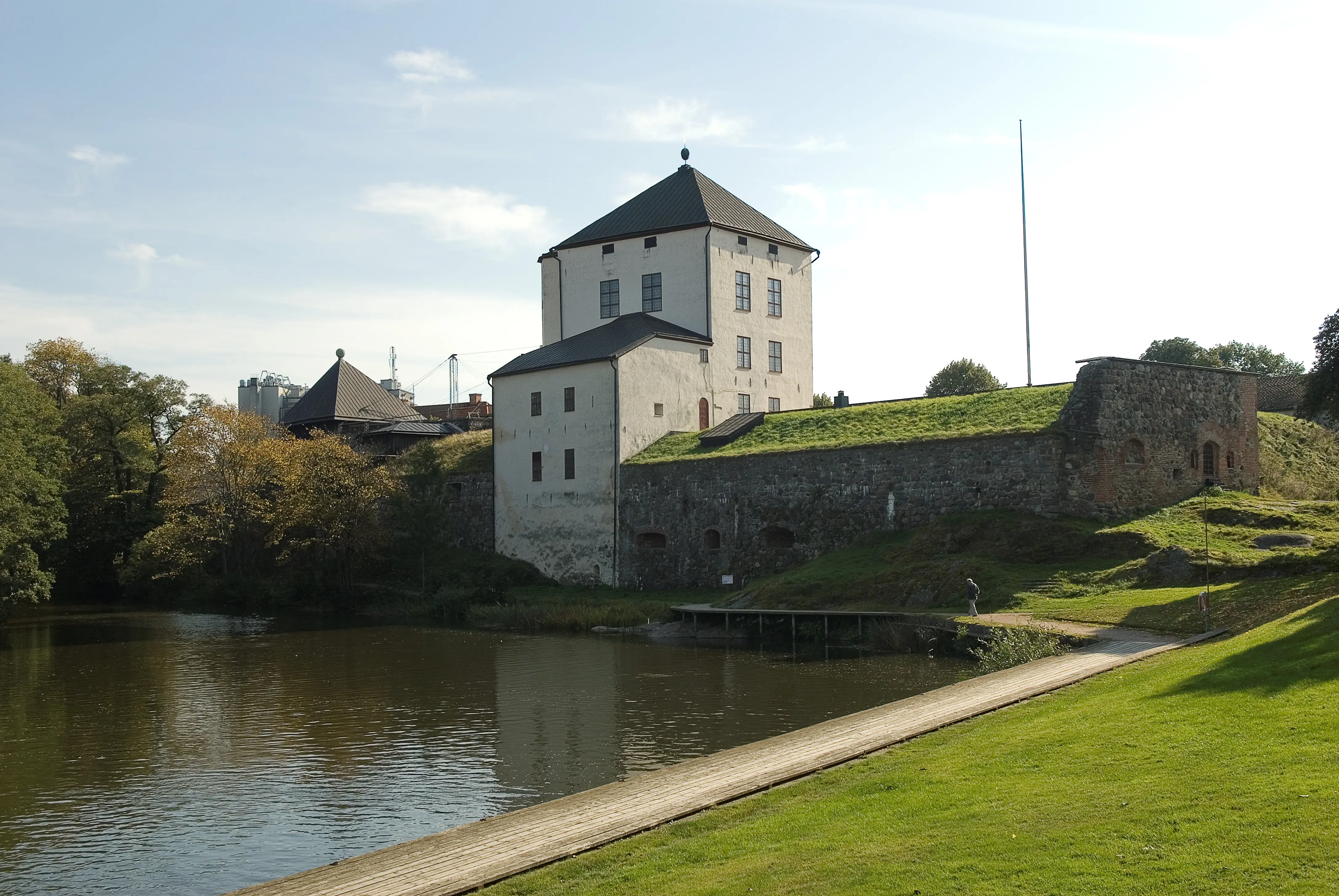 Nyköpings-hus. Kungstornet speglas i ån. Längs vattnet går en gångväg fram till slottet.