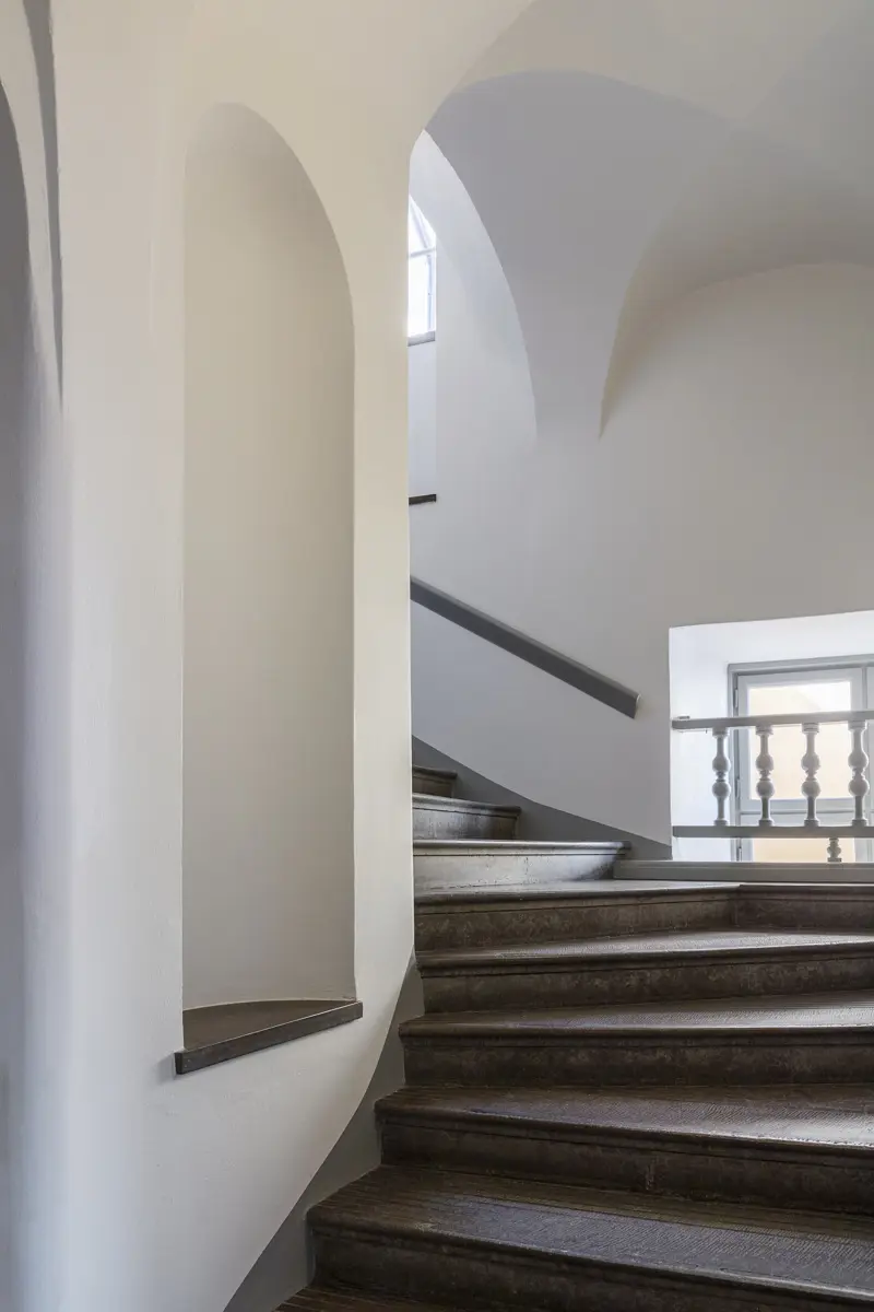 Äldre trapphus med svängd trappa i sten