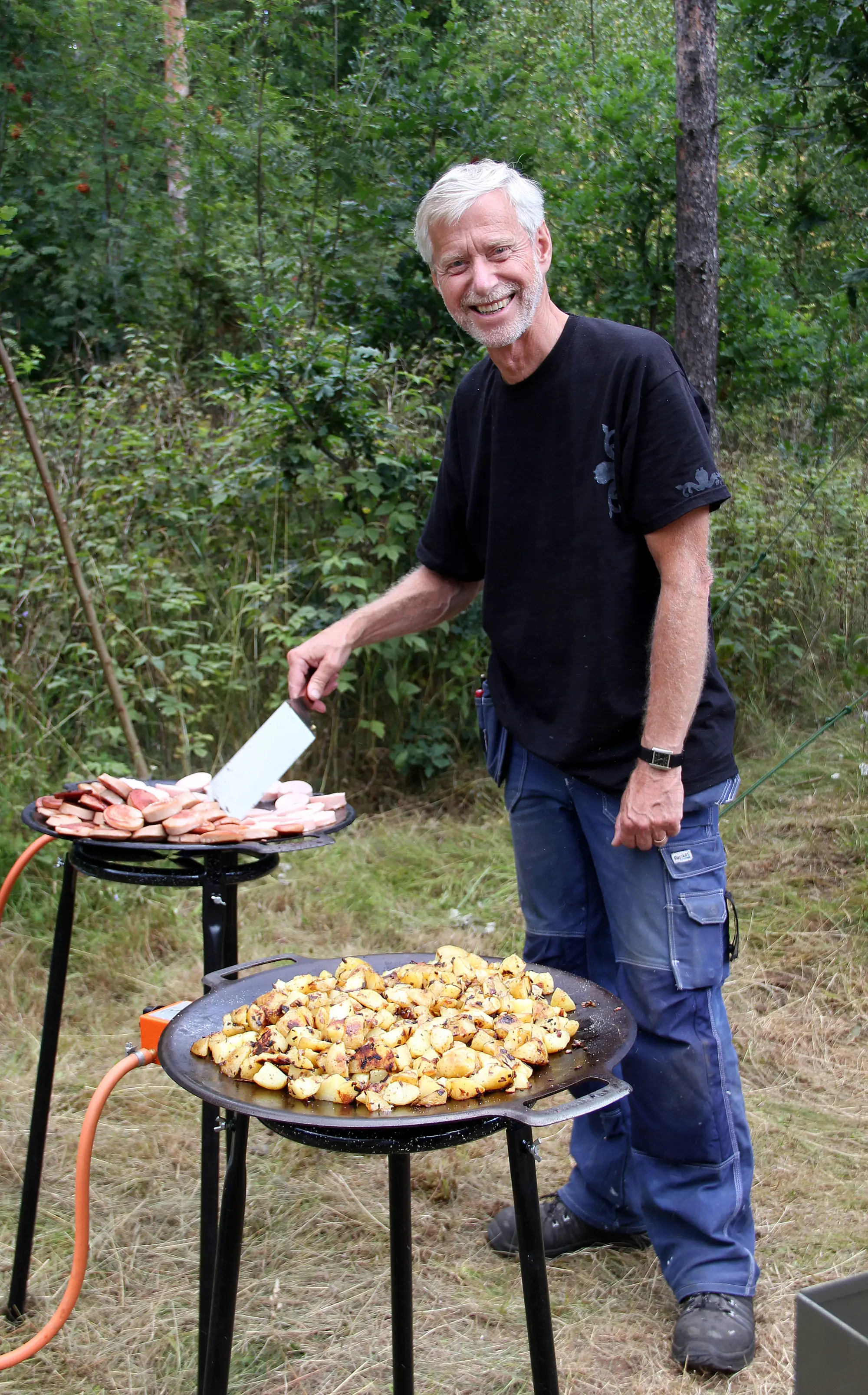 Christer Erlandsson, lägerledare, lagar mat över öppen eld.