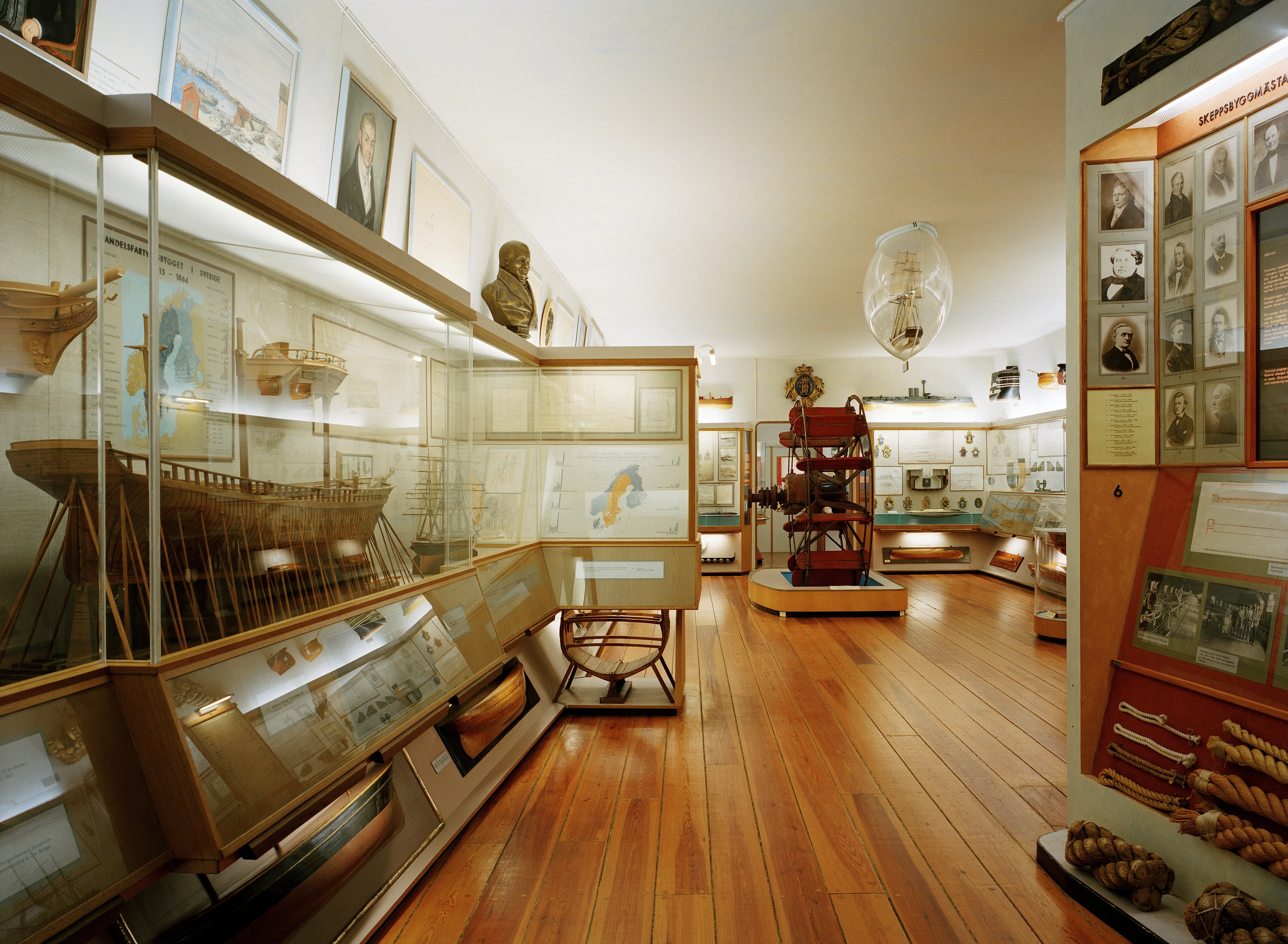 Interiör från Sjöhistoriska museet. Utställningsrum med föremål i glasmontrar.