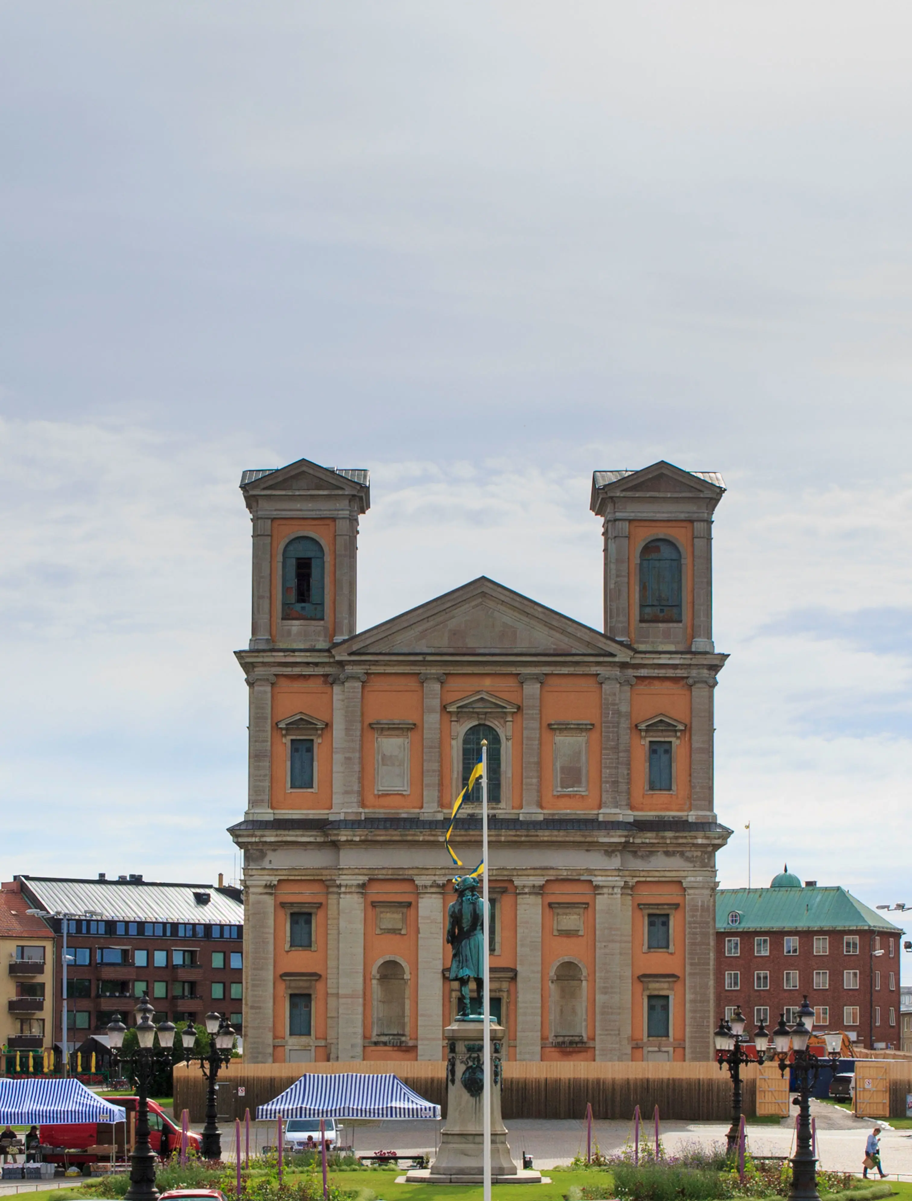 Hög, gul stenkyrka med två torn på sidan.