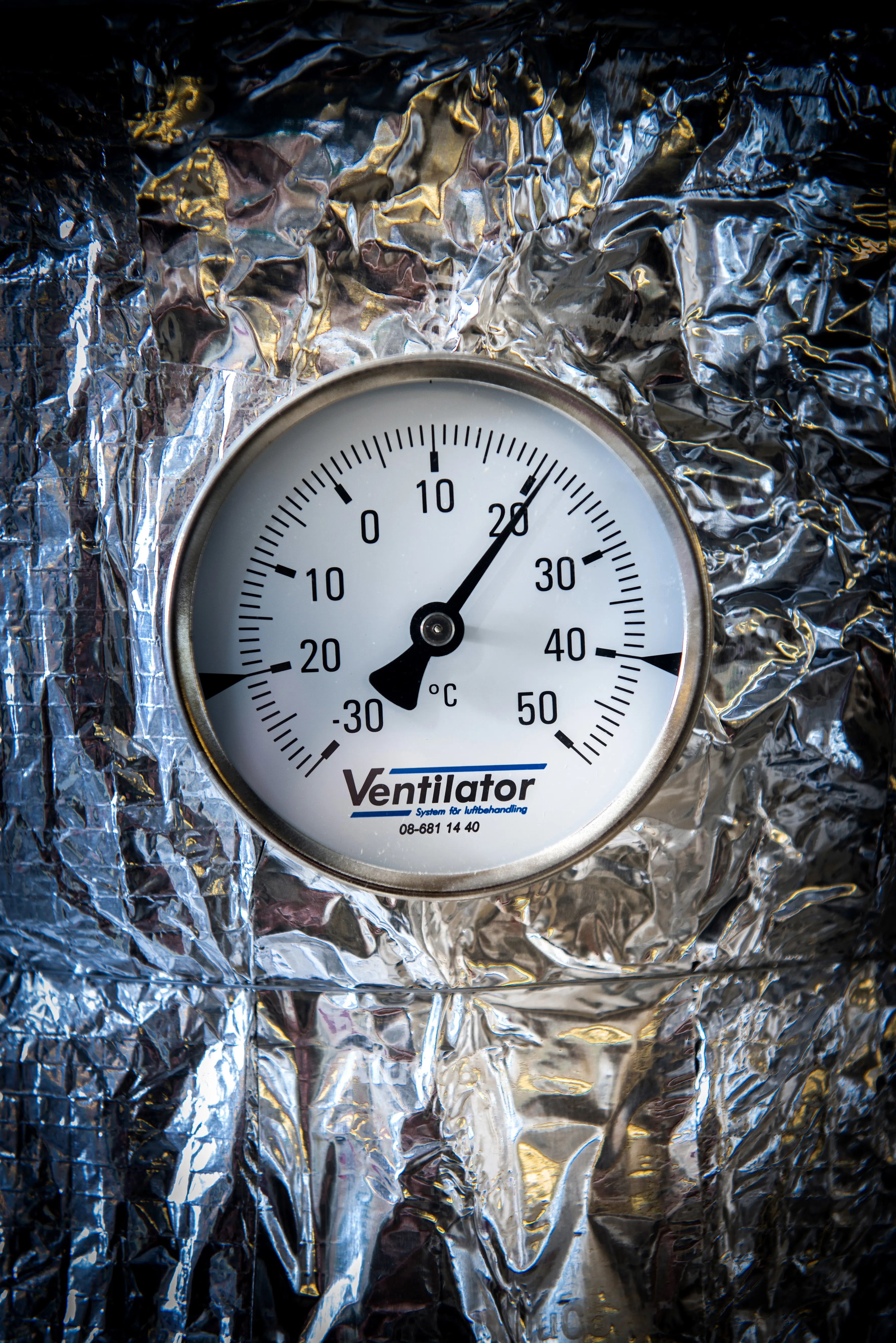 Termometer mot silvrig bakgrund.