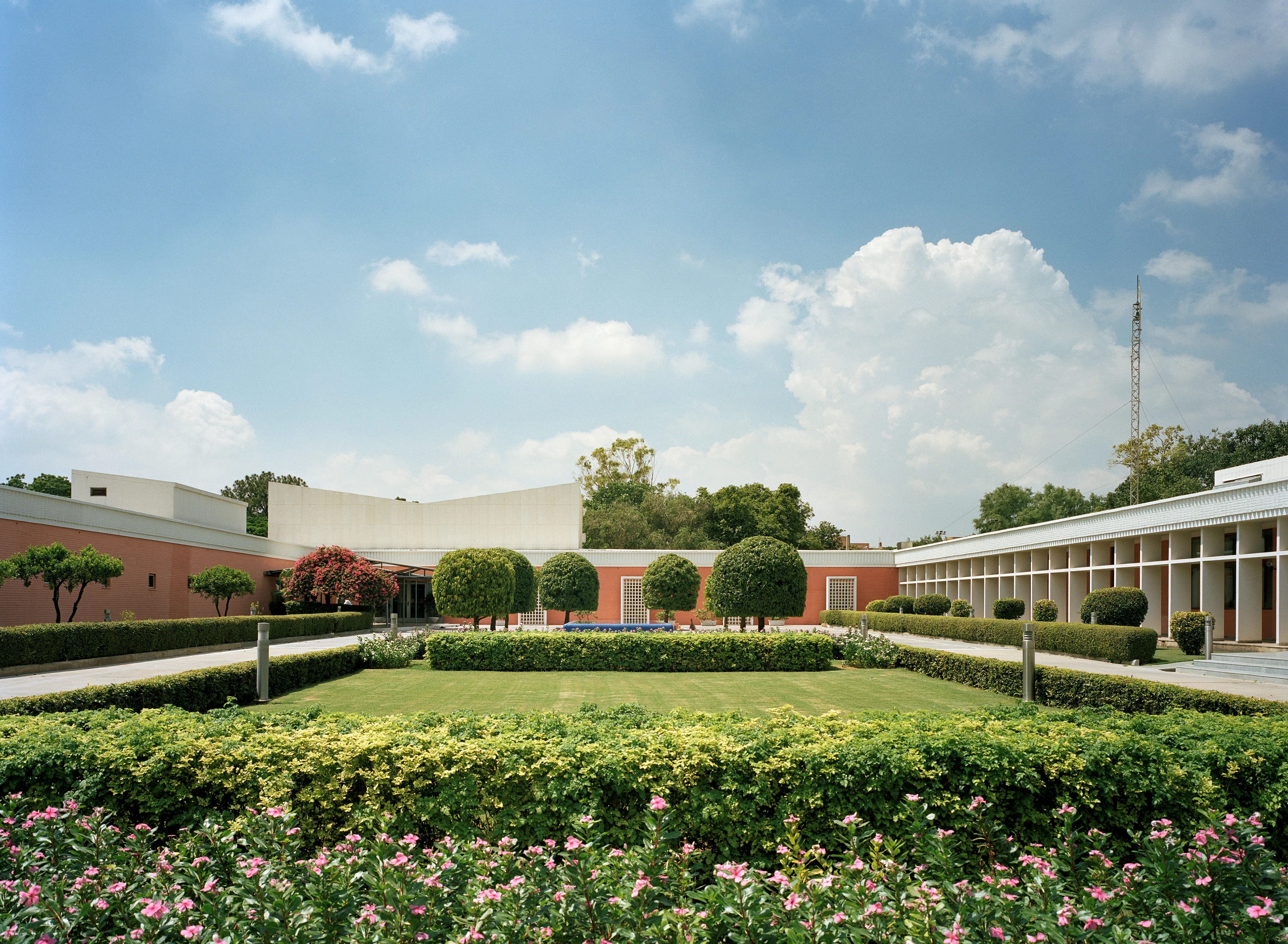 Ambassaden i New Delhi. Trädgården består av prydliga gräsytor, blommande buskar och formklippta träd.