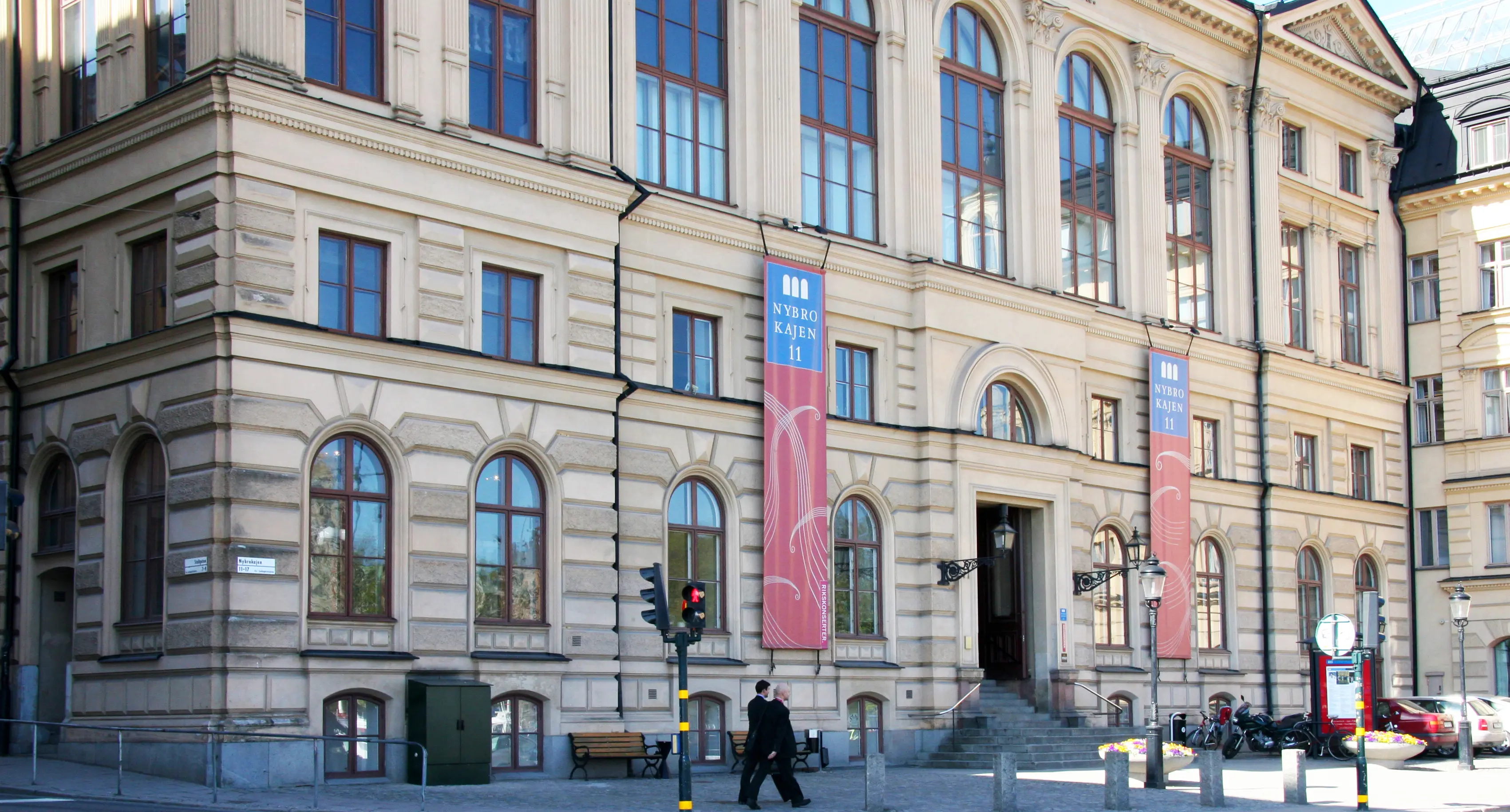 Kungliga Musikaliska Akademien. Entréfasad med stora, rundbågiga fönster och klassicistisk dekor.