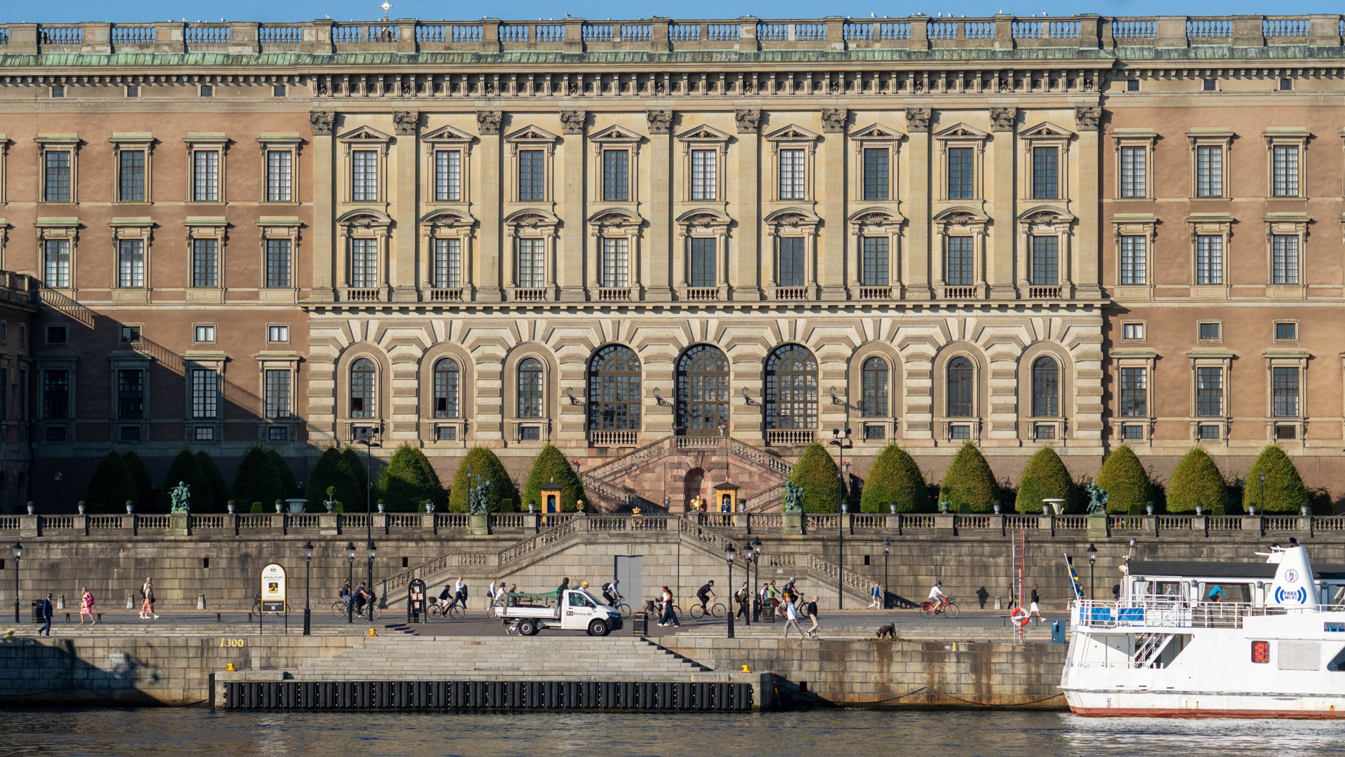 Stockholms slotts fasad med Logårdstrappan och Skeppsbron. Slottet har olika bruna nyanser.