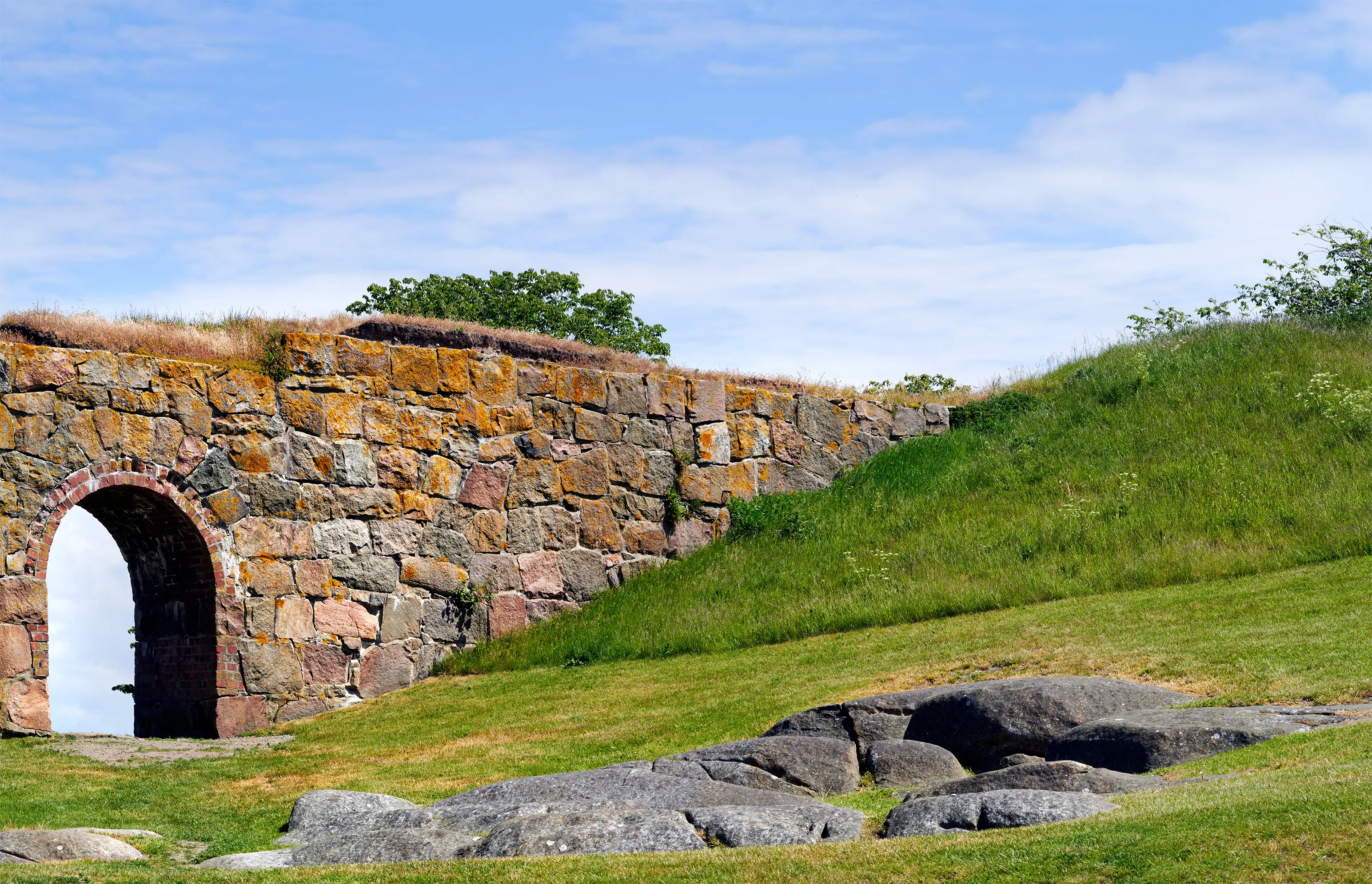 Fästningsmur med portal ut mot havet.