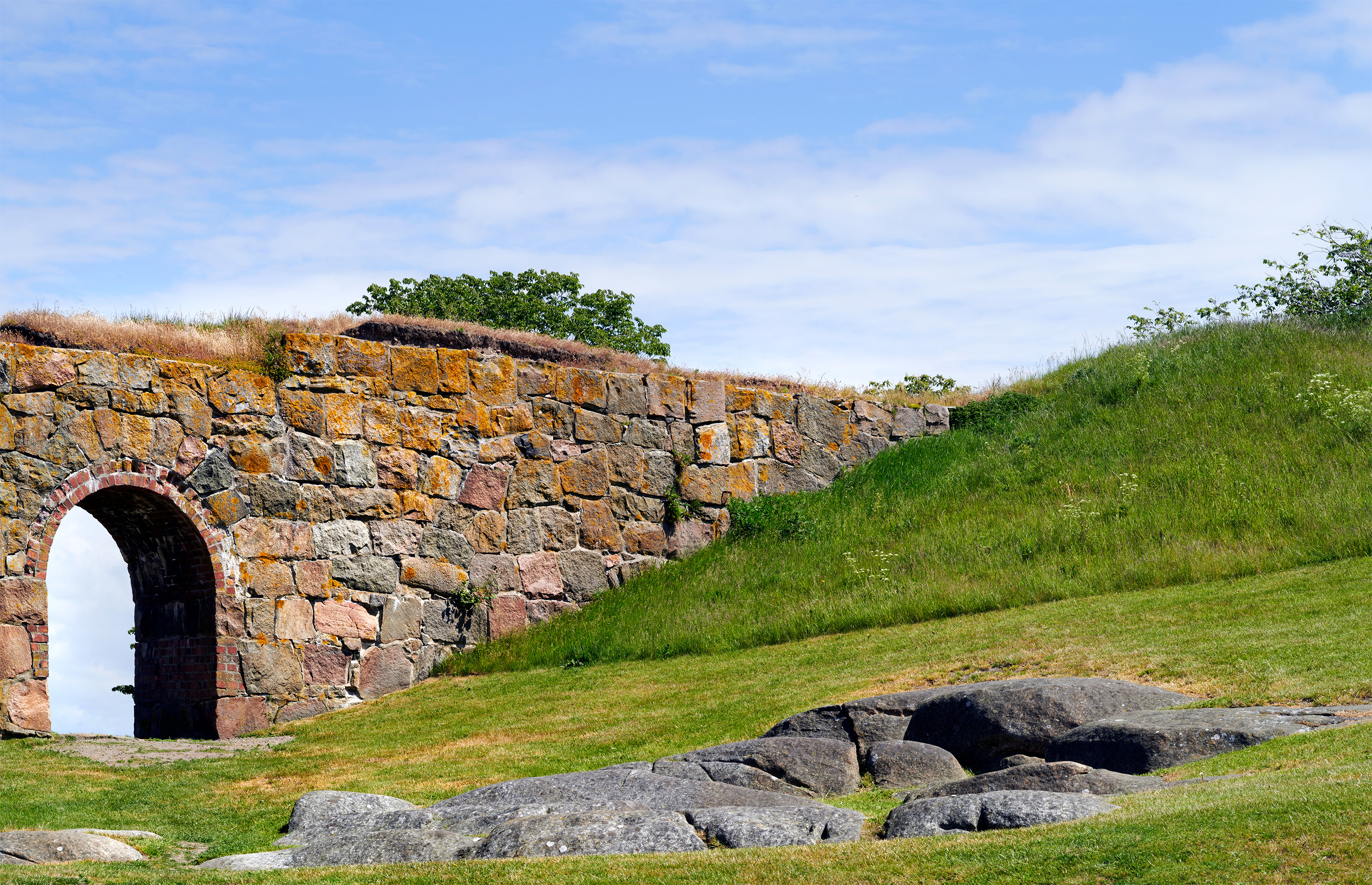 Fästningsmur med portal ut mot havet.