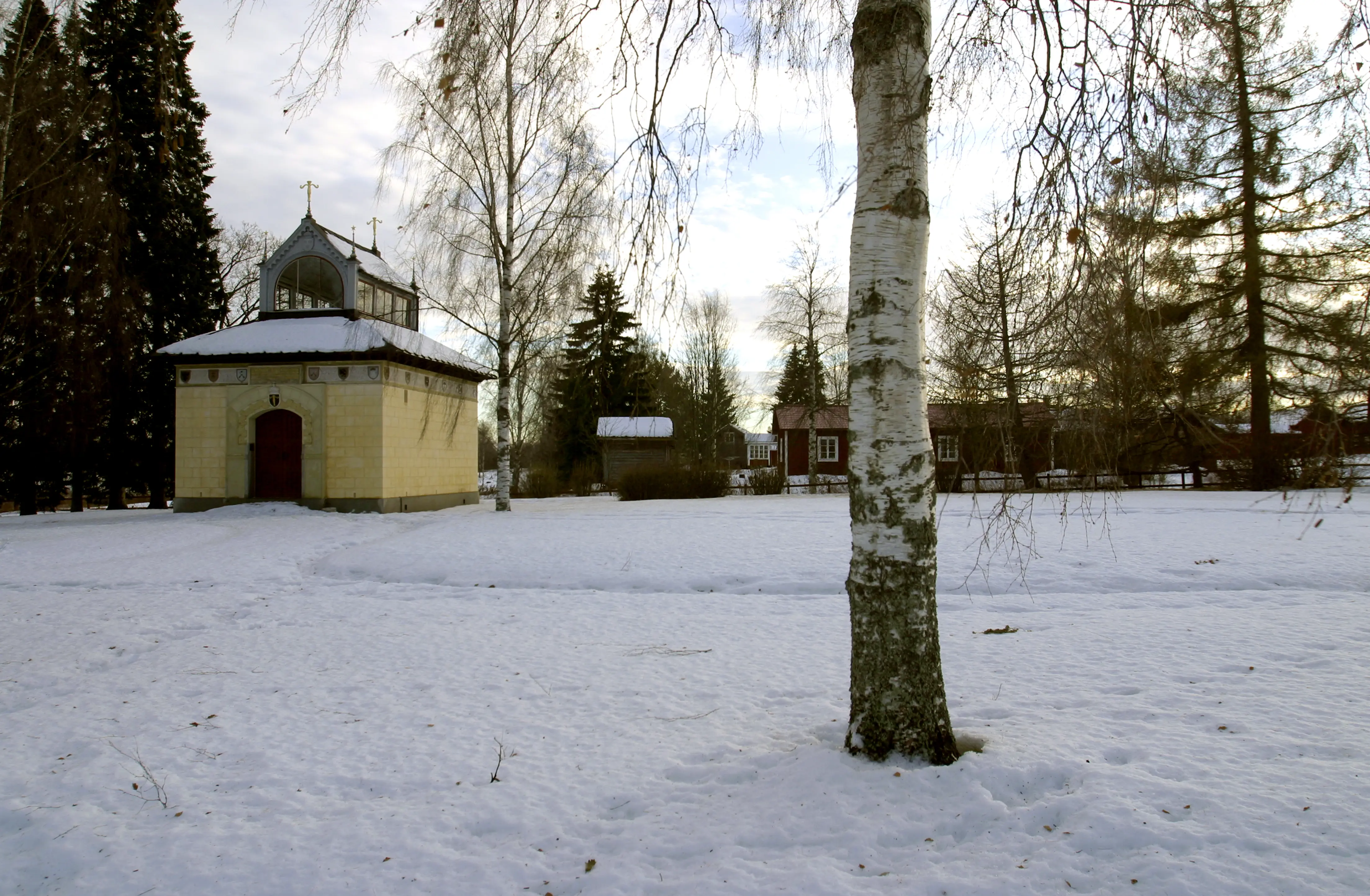 Vasamonumentet vid Utmeland. Liten byggnad i gul sandsten med en stor lanternin på taket. Vinter och snö.