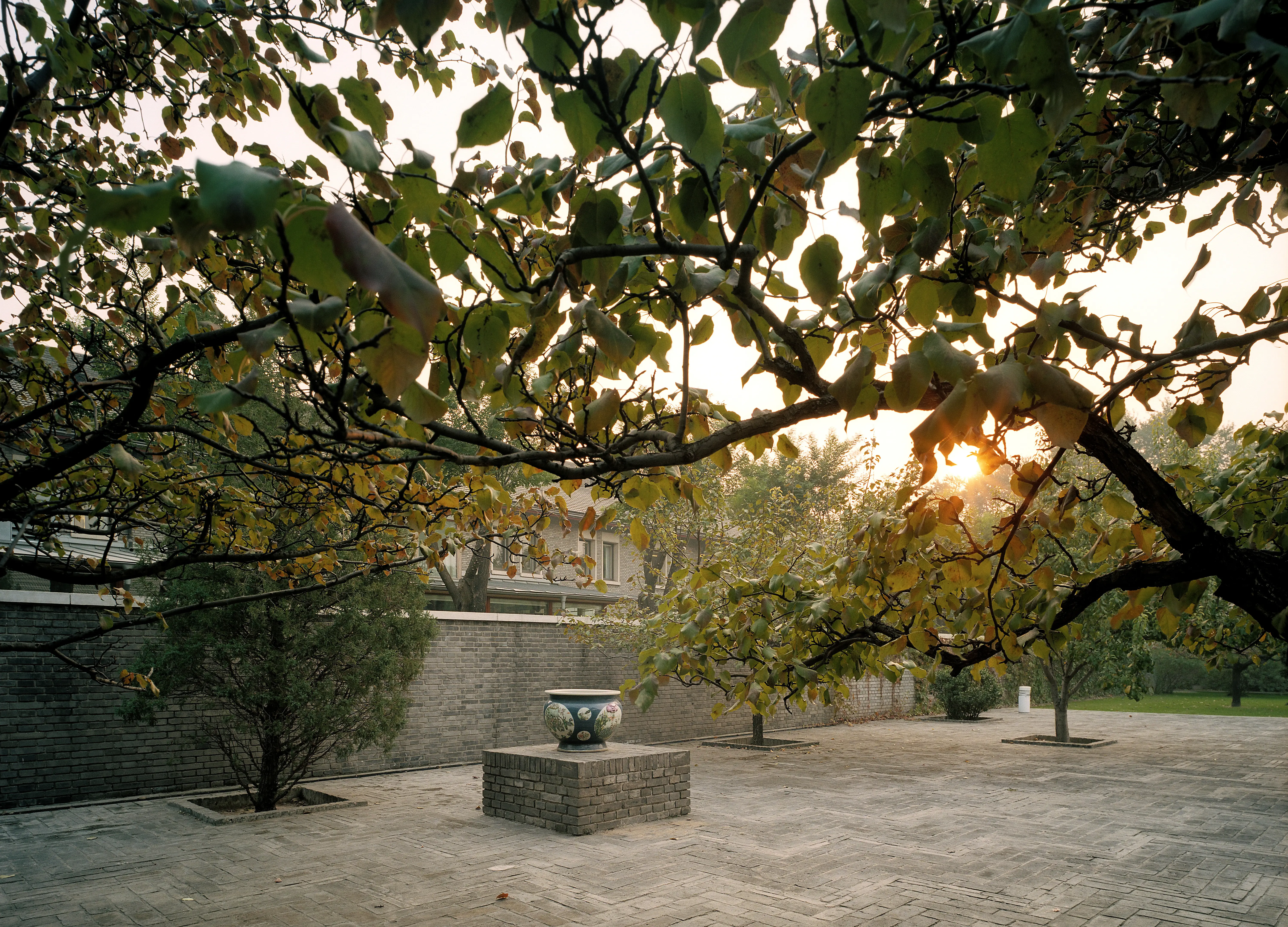 Innergården till ambassaden i Peking. Marken är stenlagd, med enstaka träd. På en sockel står en stor urna.