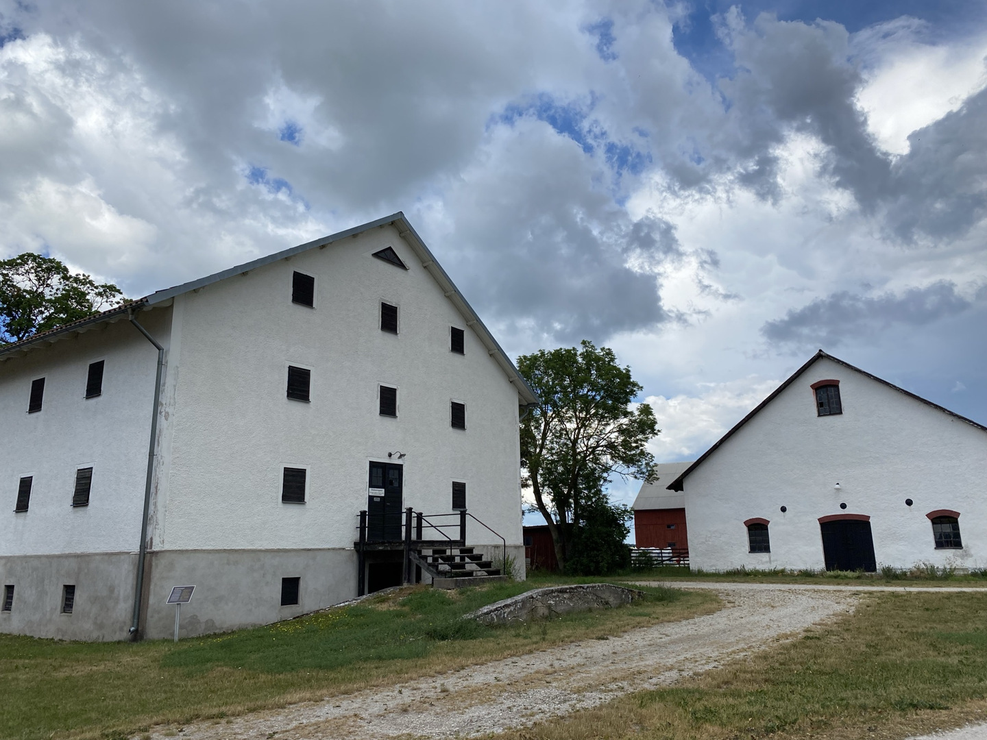 Roma kungsgård. Två större, vitputsade ekonomibyggnader för jordbruk.