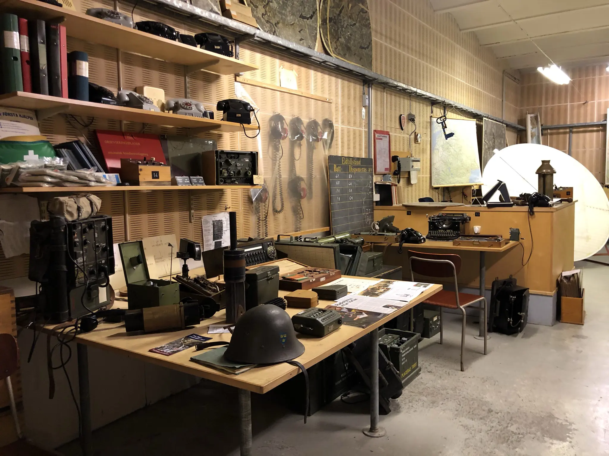 Bodens fästning. Stort kontorsrum med gammal teleteknik och kartor.
