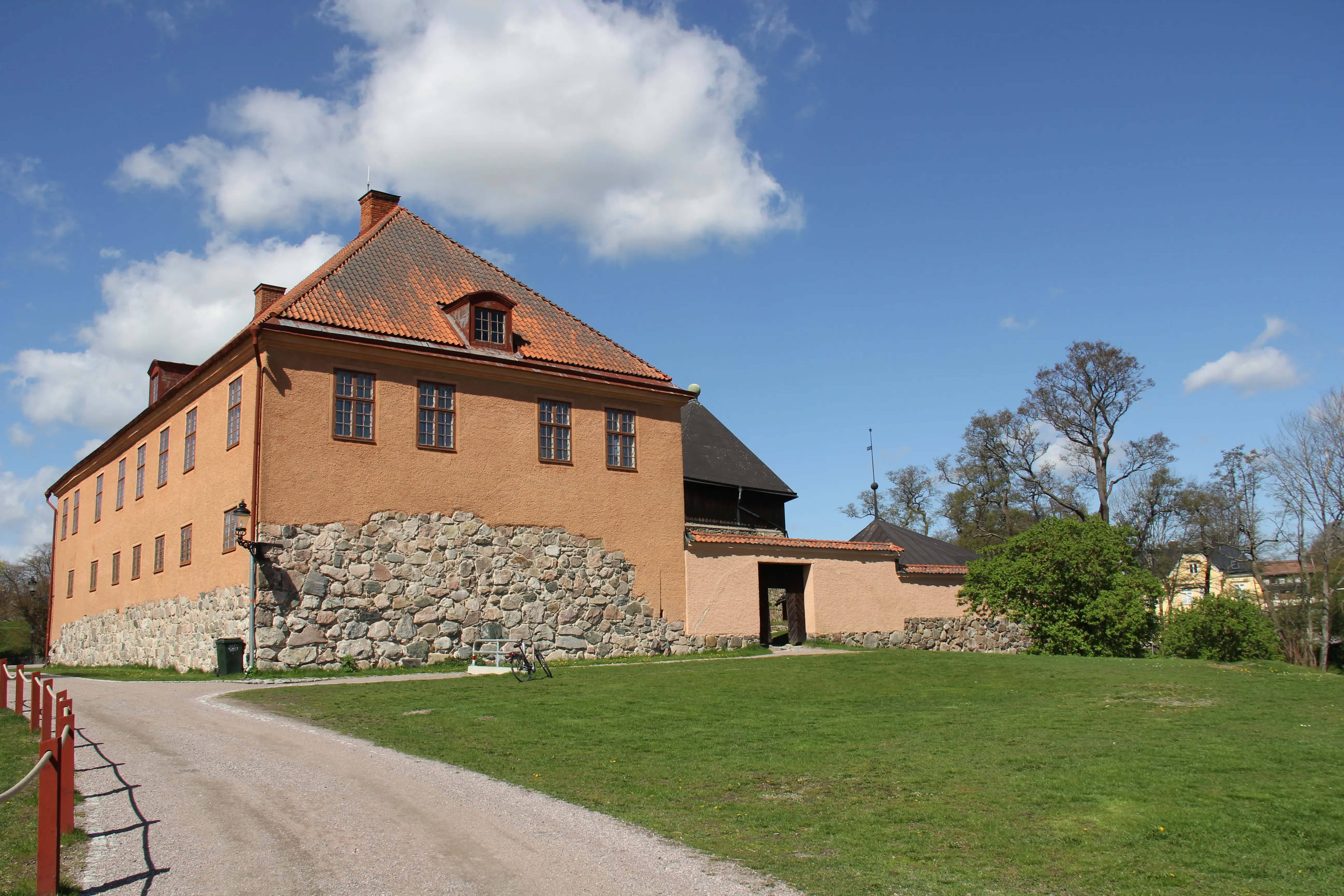 Nyköpingshus, gamla residenset. Ett stenhus i två våningar med brun puts. Det valmade tegeltaket är brant och har tak-kupor.