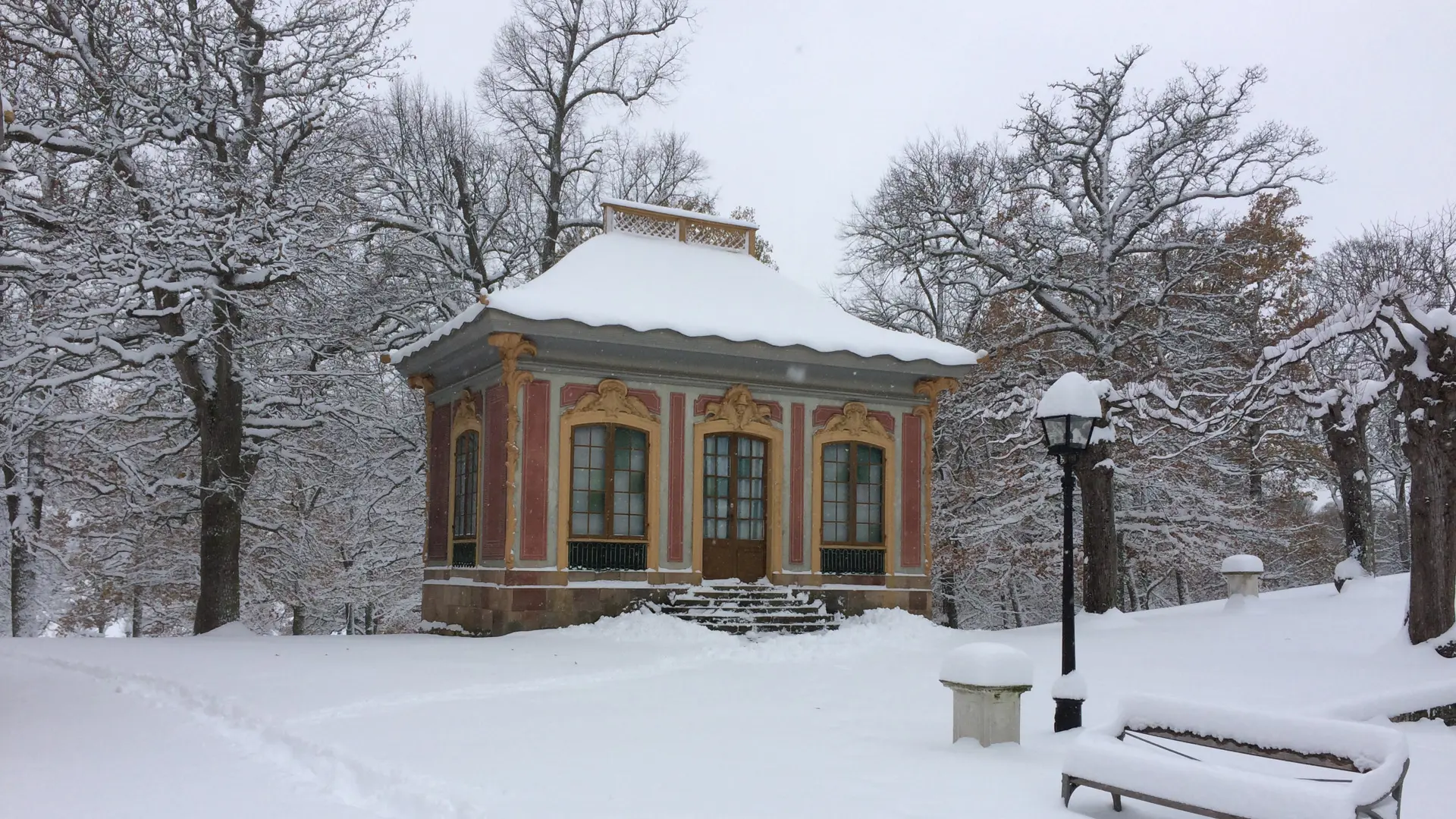 Silverkammaren vid Kina slott, Drottningholm. Liten röd paviljong med gul dekor. Vinter och snö.