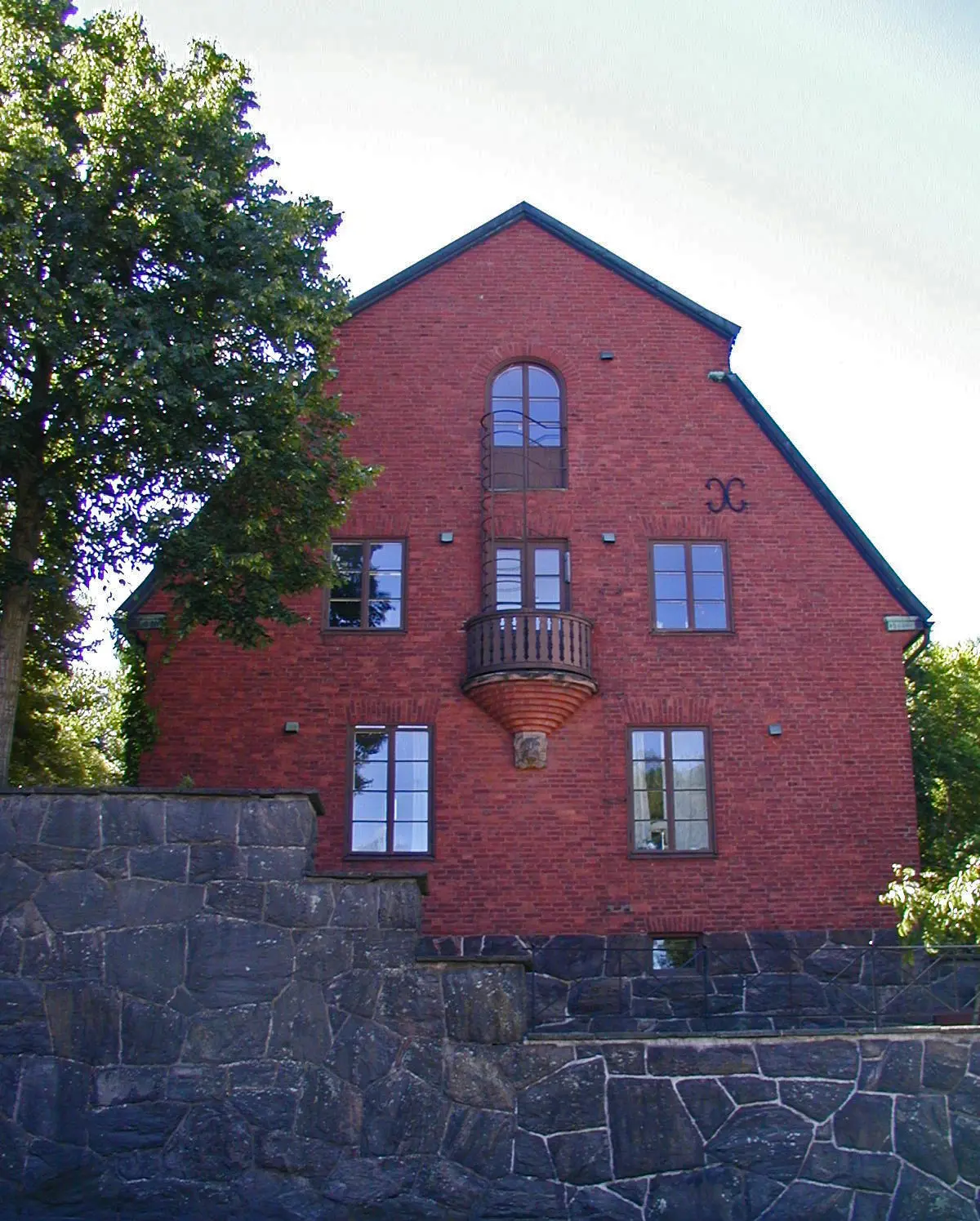 Villa Smedmark, Lorensberg. Rött tegelhus i tre våningar med brutet tak.