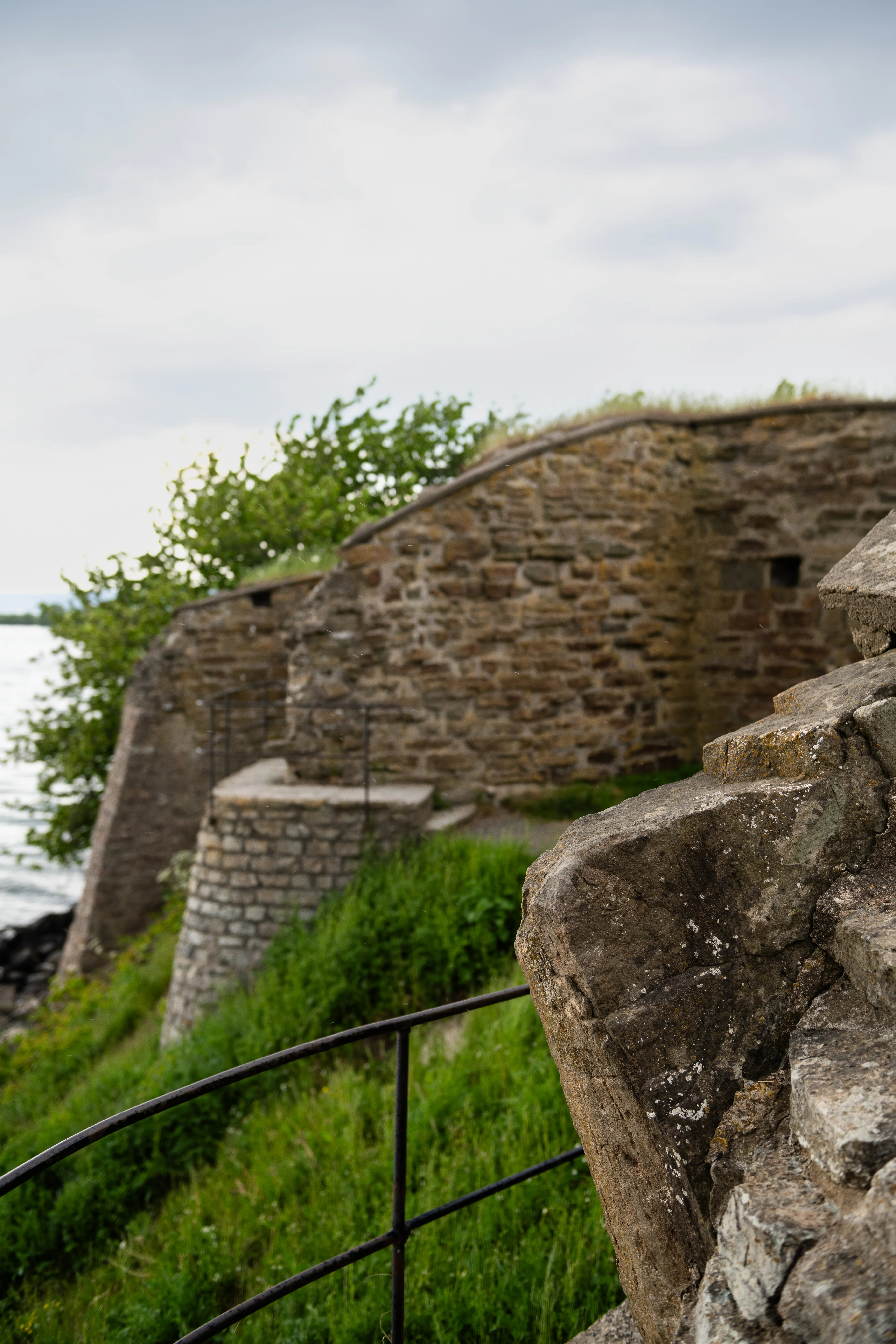 Näs slottsruin. Detalj av stenfasaden. Vättern skymtar i bak-grunden.