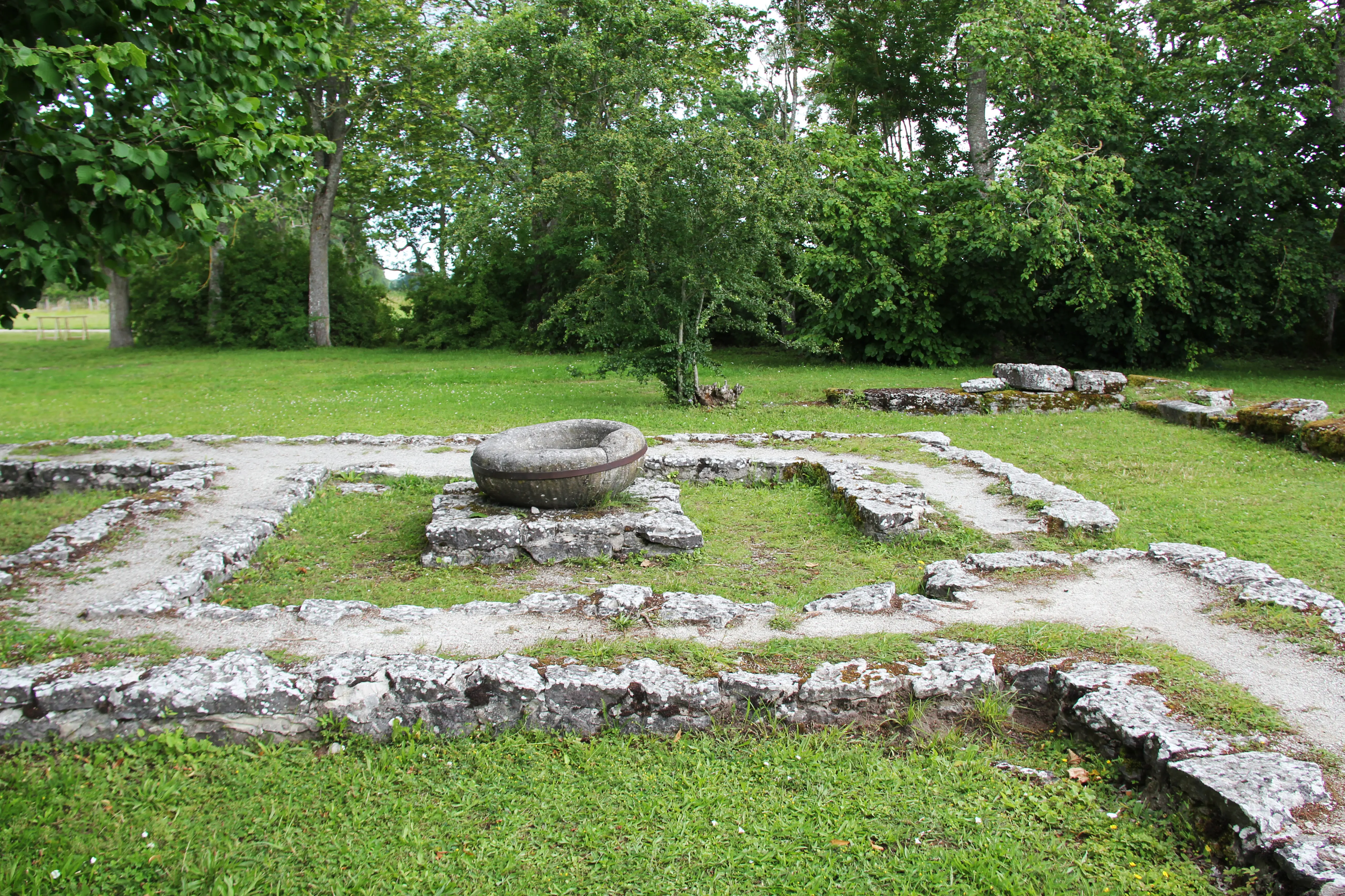 Parken bakom Roma klosterruin, med rester av stenmurar.