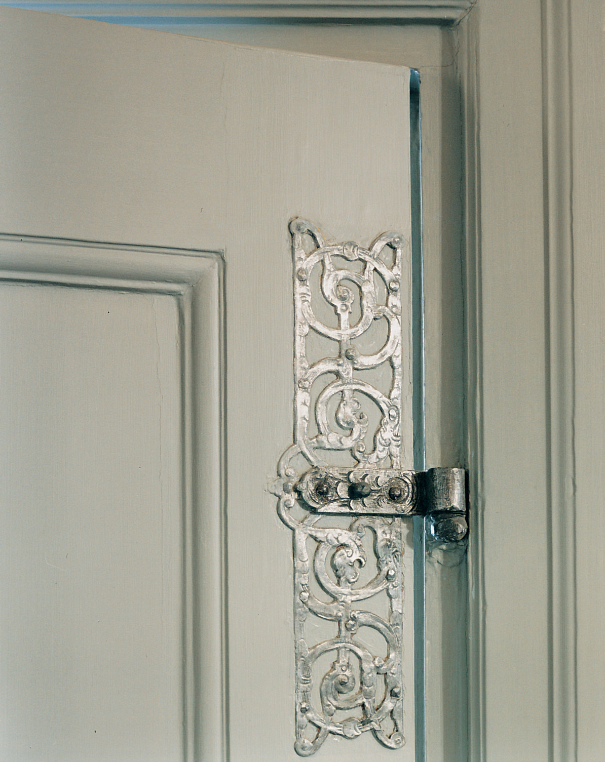 Oxenstiernska palatset. Inredningsdetalj. Närbild på ett sirligt, silverfärgat gångjärn.