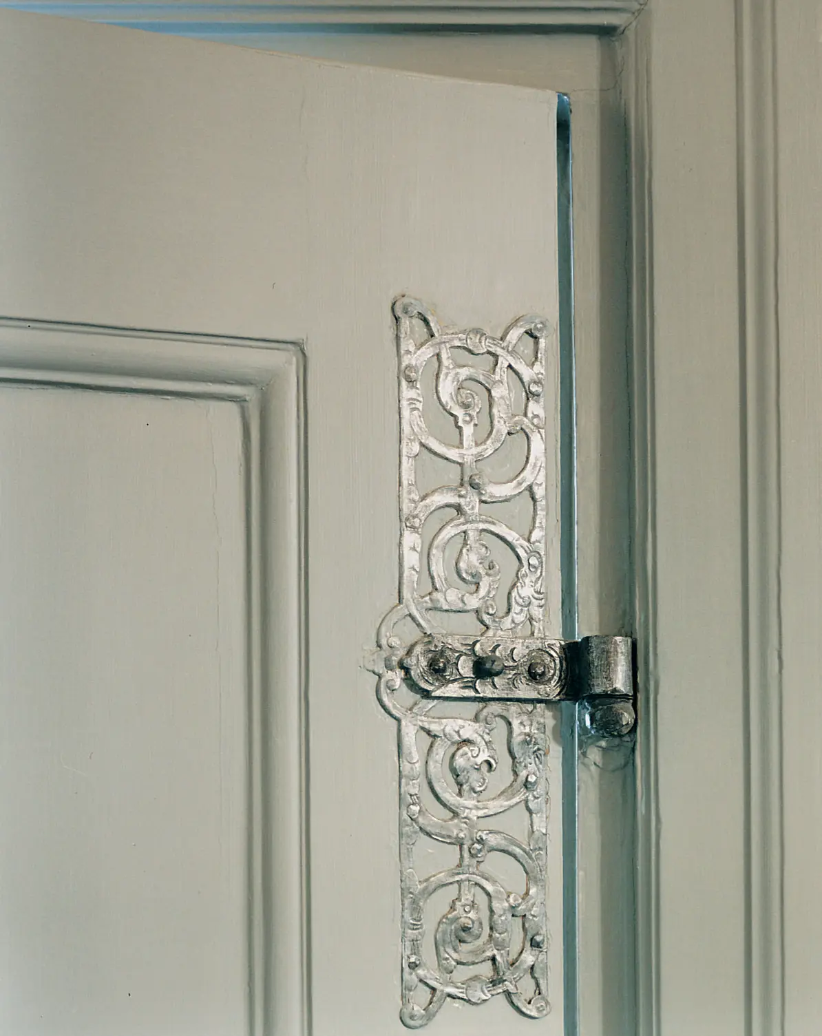 Oxenstiernska palatset. Inredningsdetalj. Närbild på ett sirligt, silverfärgat gångjärn.