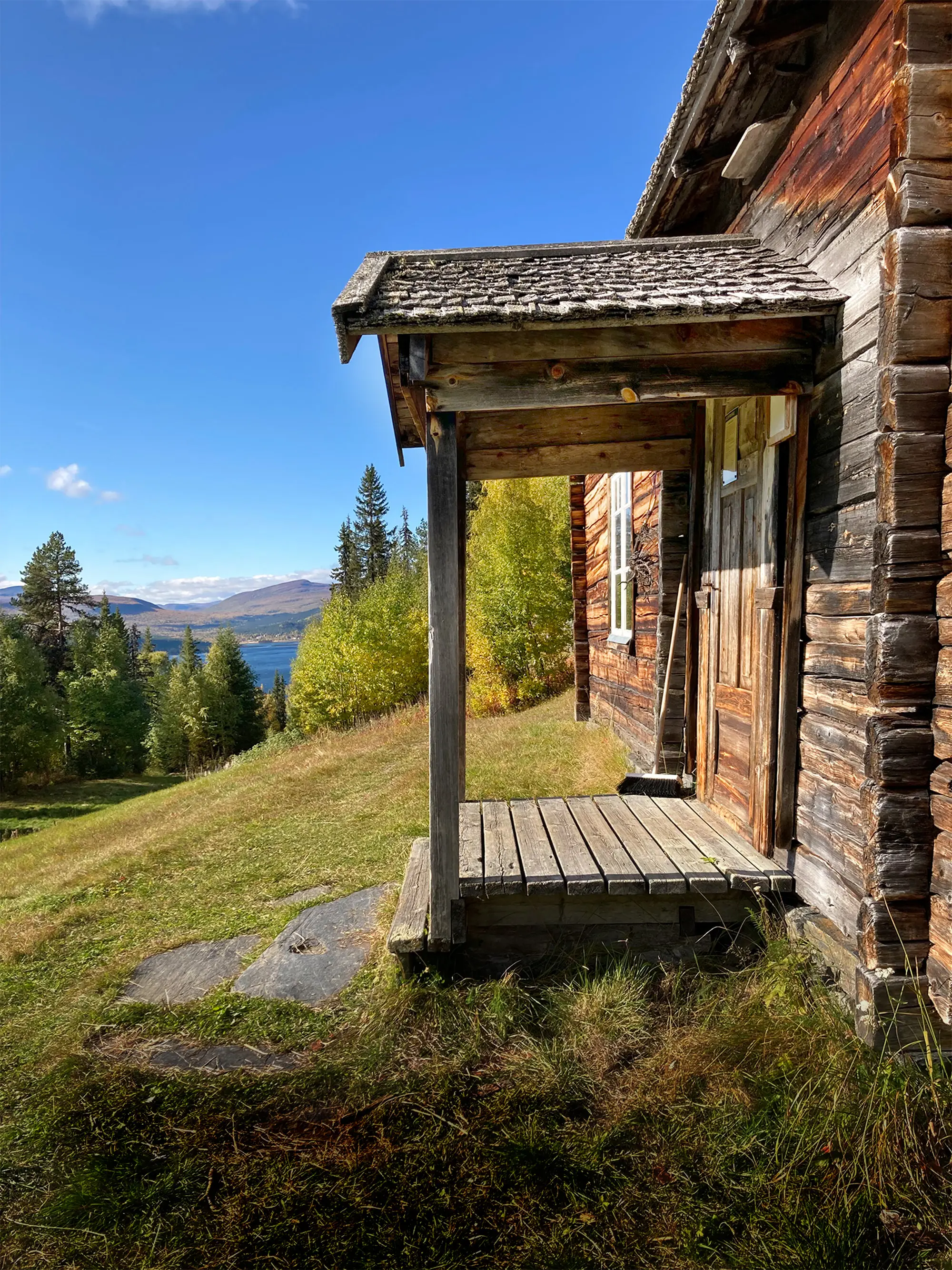 Från förstukvisten på Örnbo kan vandraren både vila benen och ögonen. Den högt belägna gården vänder sig mot solen i sydöst.