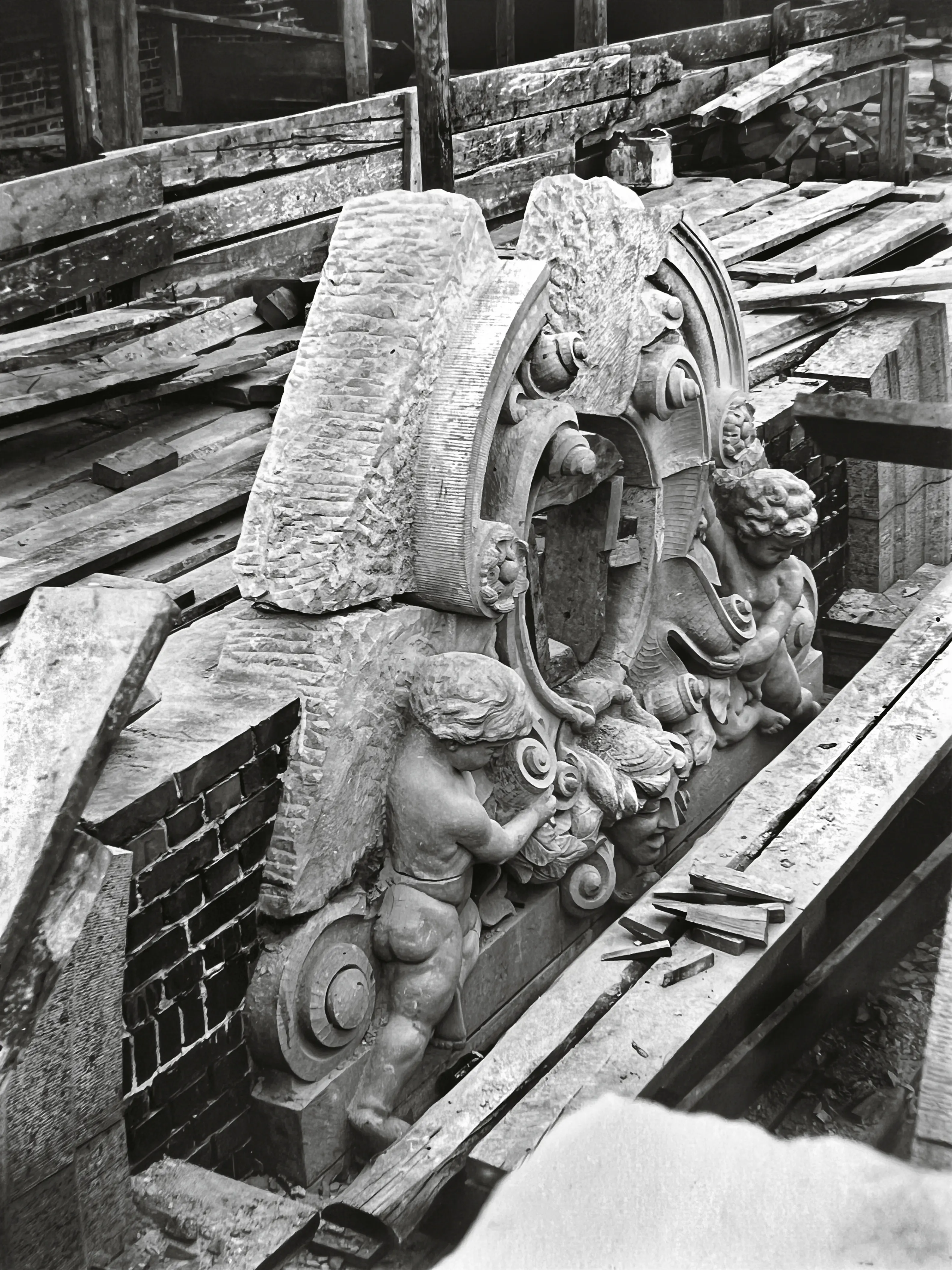En av tre utsmyckningar i kalksten omkring medaljongerna av Jenny Lind, Frans Berwald och Adolf Fredrik Lindblad. Sparsamhet på dekorativa effffekter måste iakttagas. Nästan all dekoration är därför koncentrerad på teaterns mittparti åt Gustaf Adolfs torg.