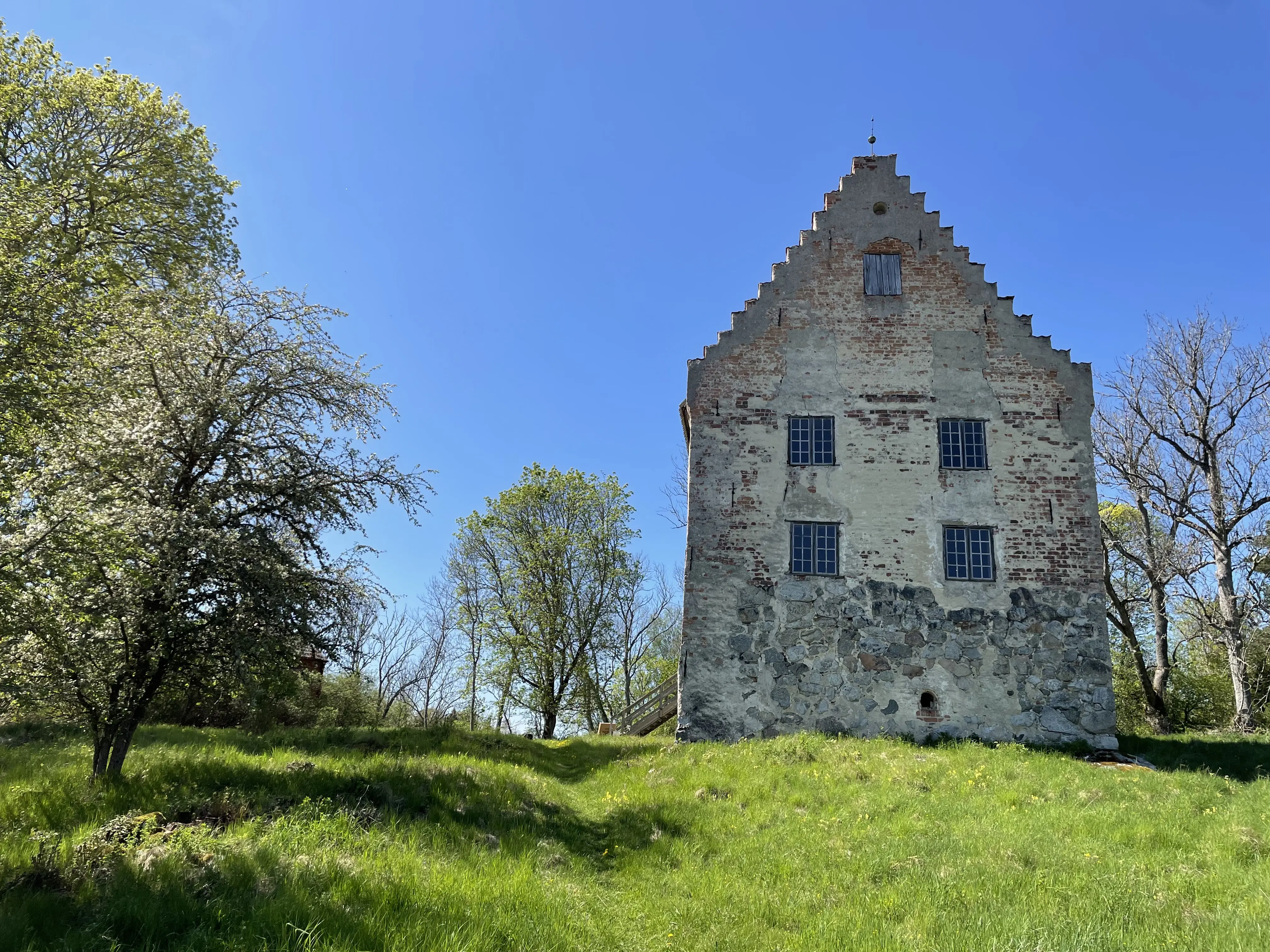 Utö hus, en borg-liknande tegelbyggnad med trappstens-gavel. Fasaden har ankarslut och avflagnad puts.