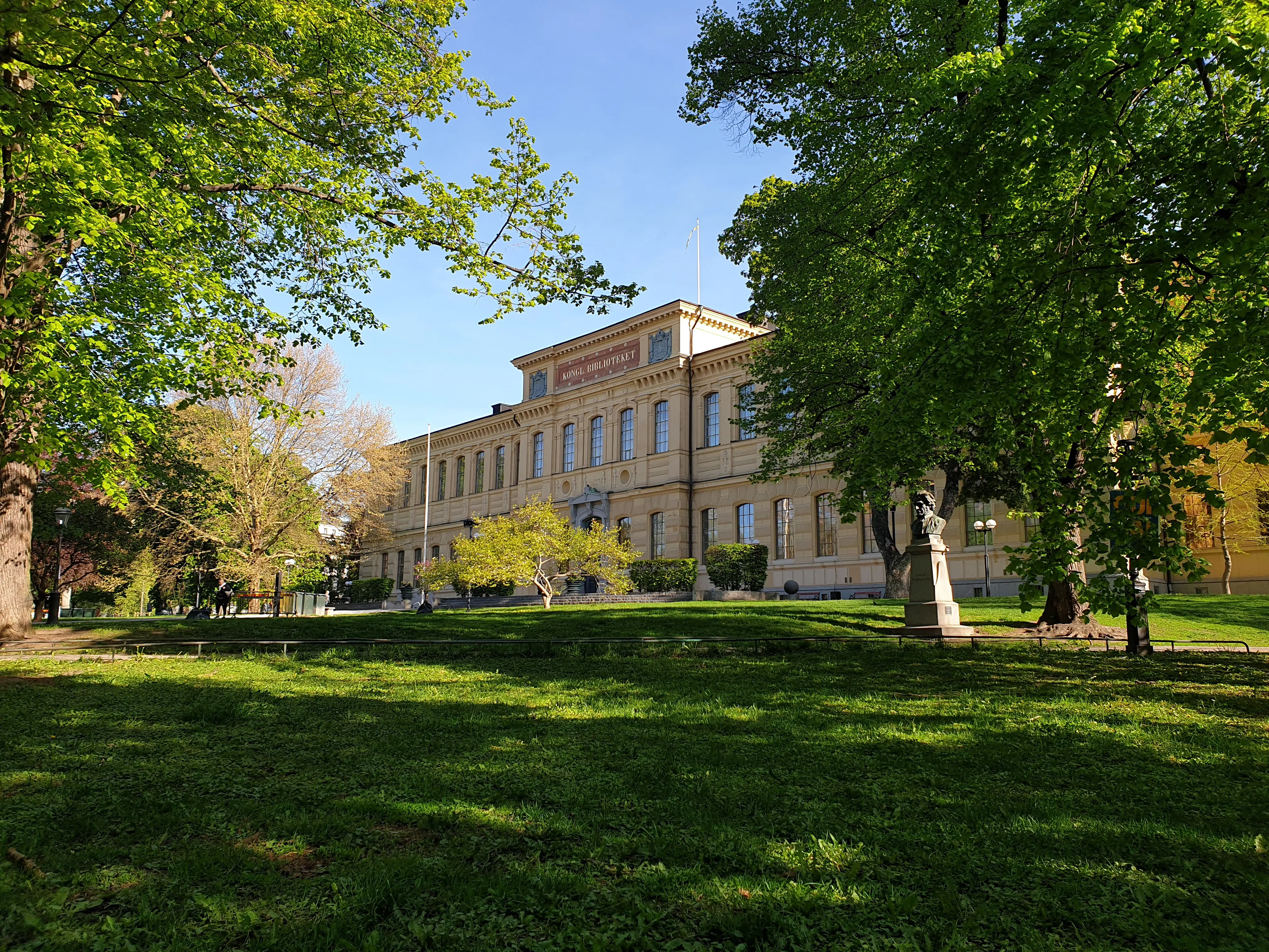 Kungliga biblioteket. En klassicistisk byggnad i två, rejält tilltagna våningar. Vår och grönska.