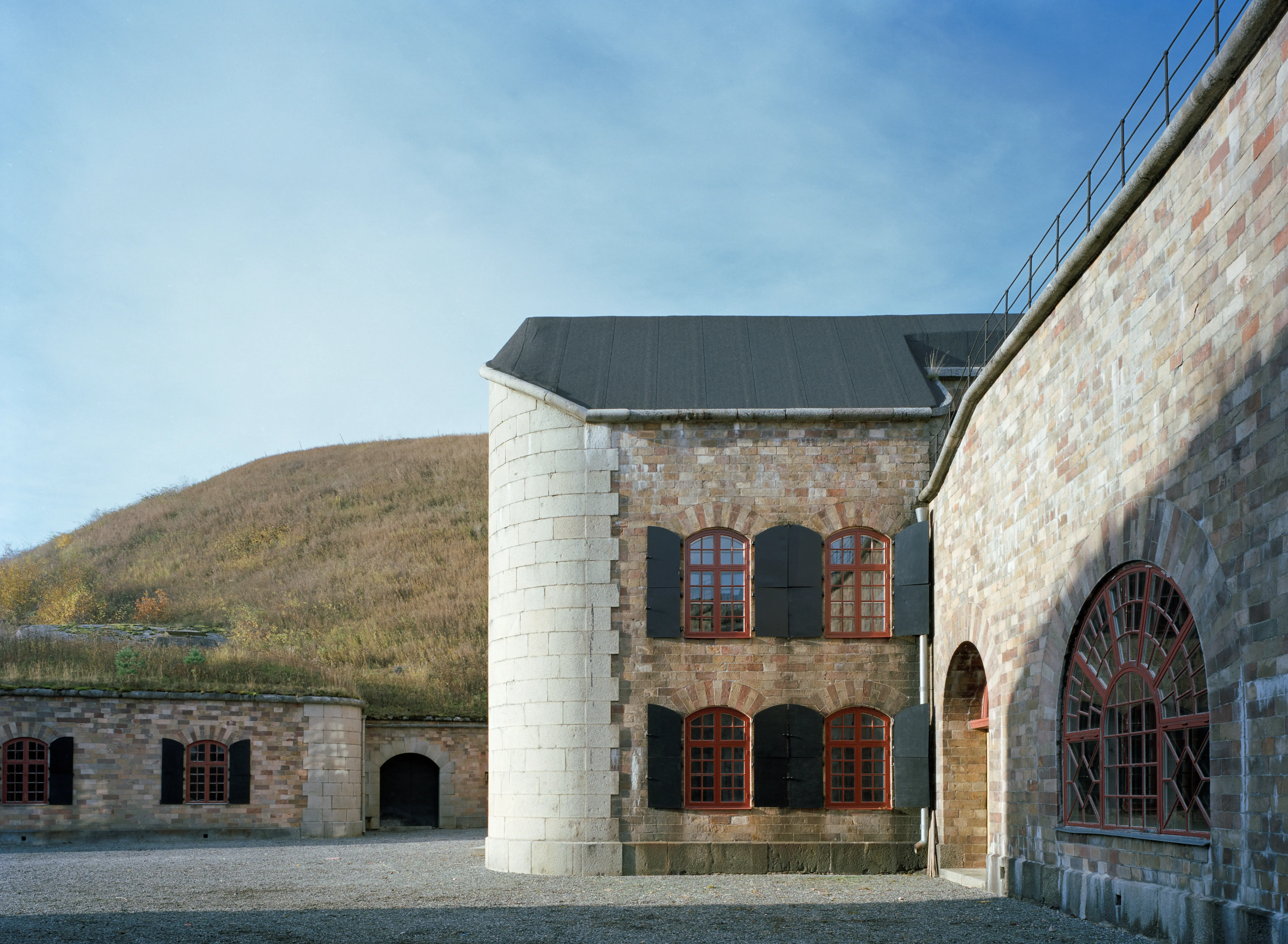 Gården i Oscar Fredriksborgs fästning. Fasaderna mot gården är av sten. Fästningen är täckt av gräs.