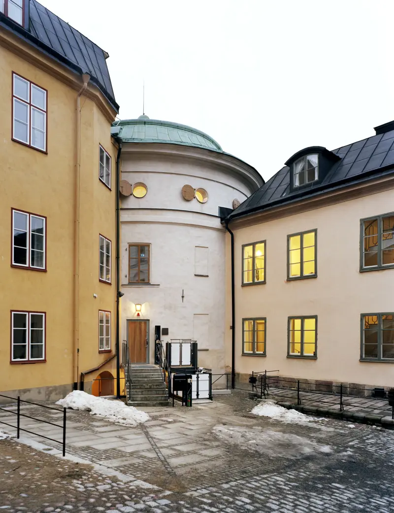 De översta våningarna på det runda tornet, sammanbyggda med de två omgivande husen.