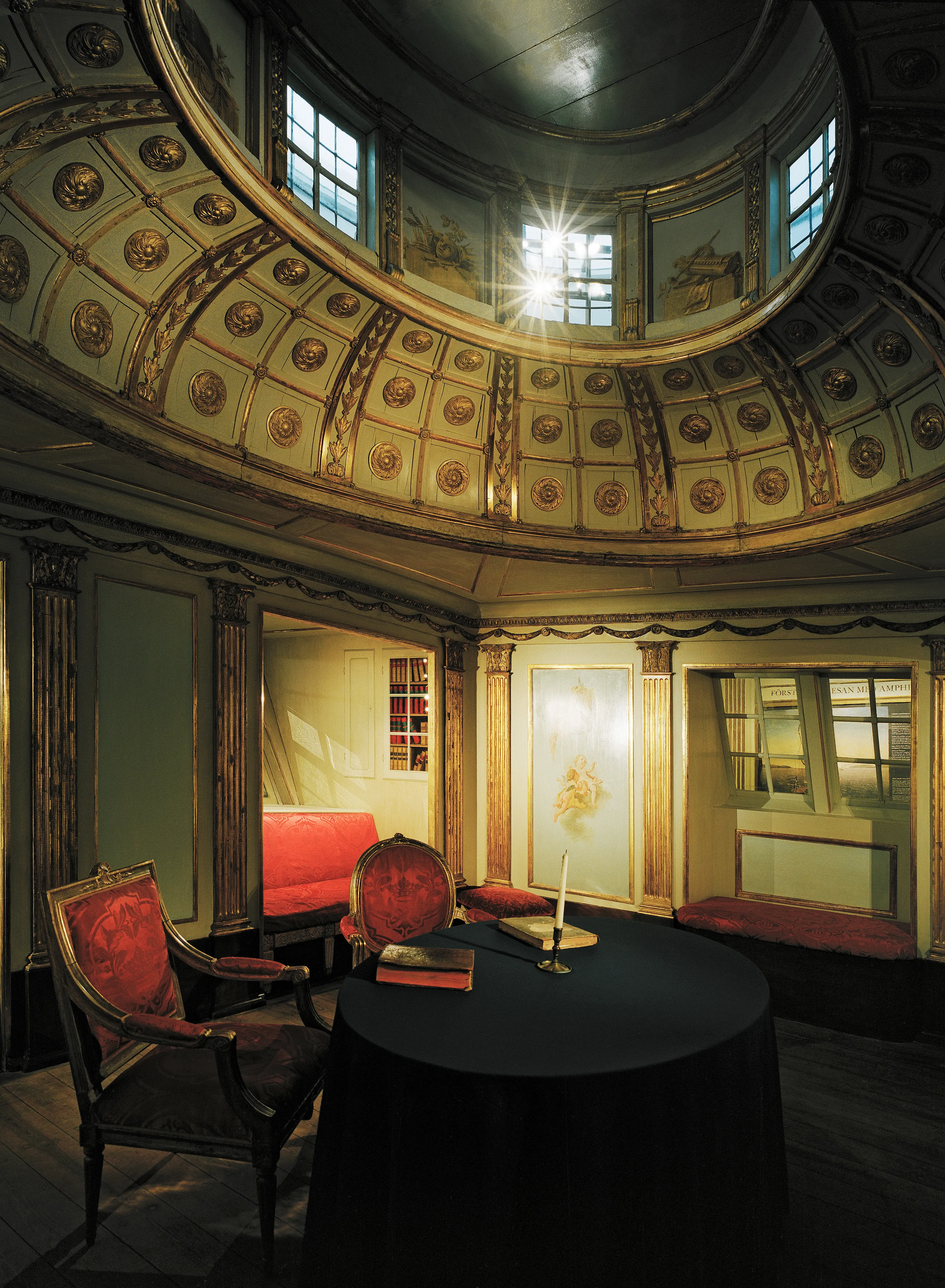 Sjöhistoriska museet. Rekonstruerad skepps-salong med röda sidenmöbler och klassicistisk, förgylld vägg-dekor.