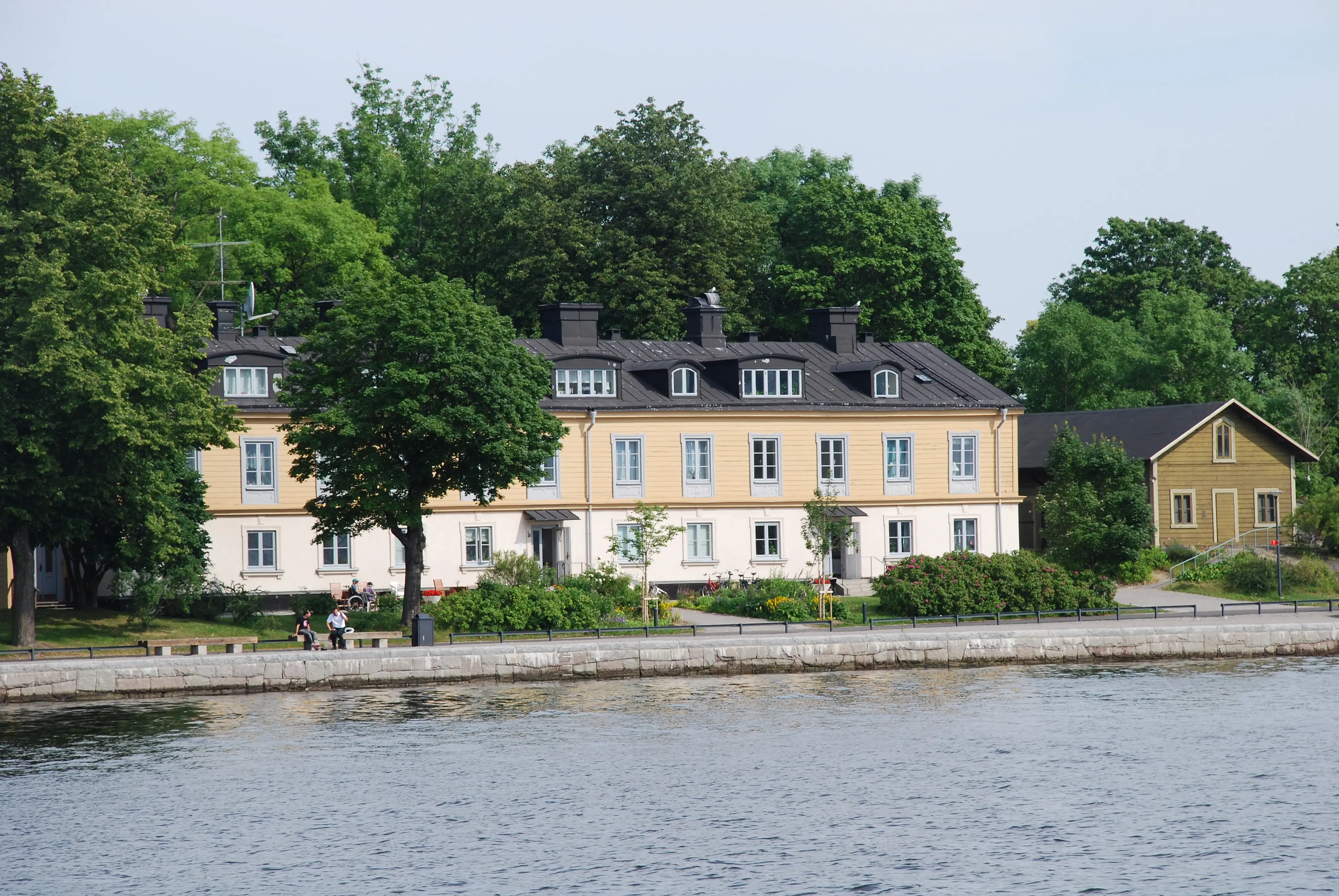 Hantverkarbostället på Kastellholmen. Klassicistisk tvåvåningsbyggnad med svart plåt-tak. Taket har omväxlande små och stora tak-kupor.