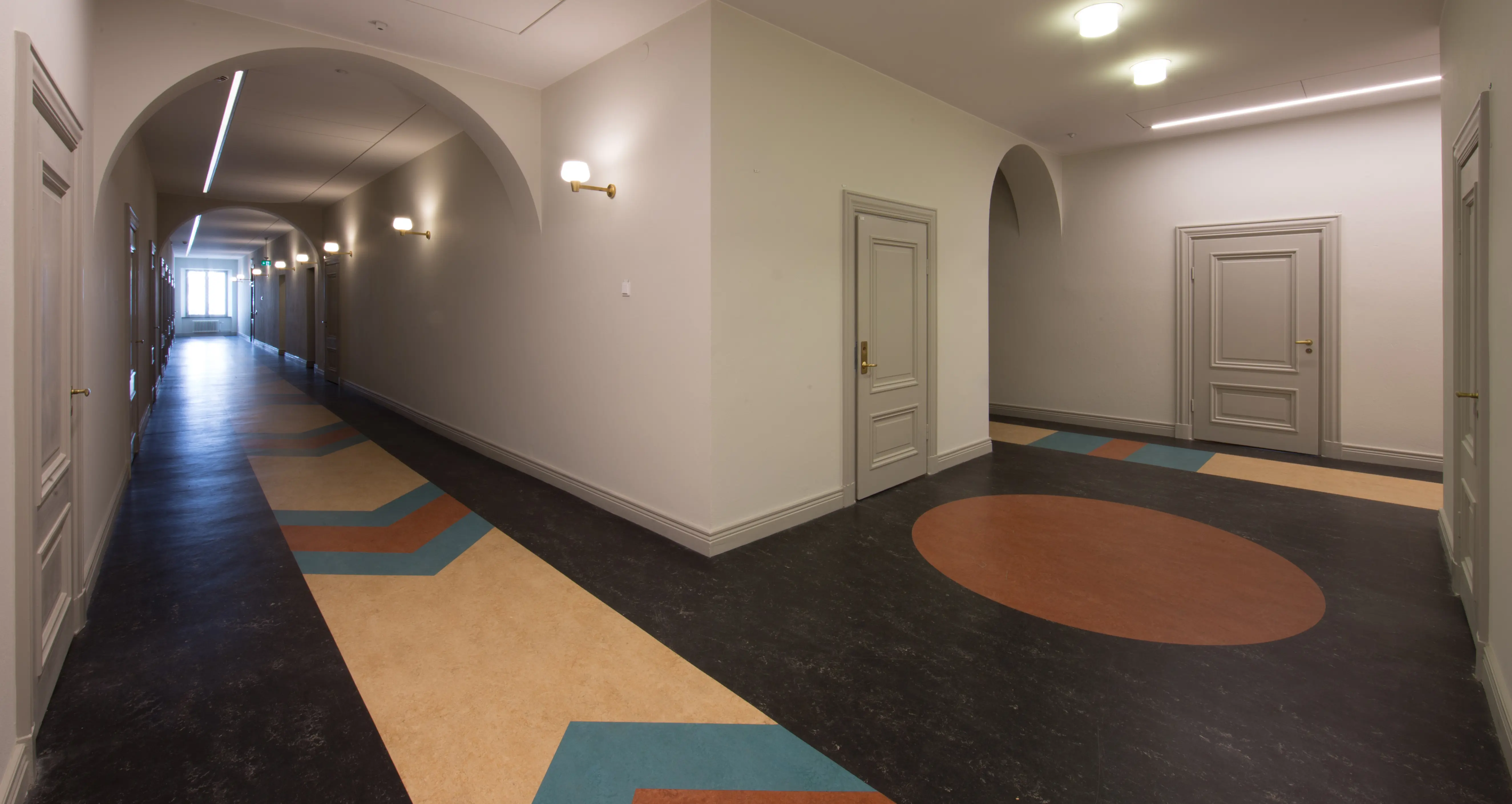 Interiör, gamla auktions-verket. Korridor med linoleum-matta i svart, brunt, beige och turkos.