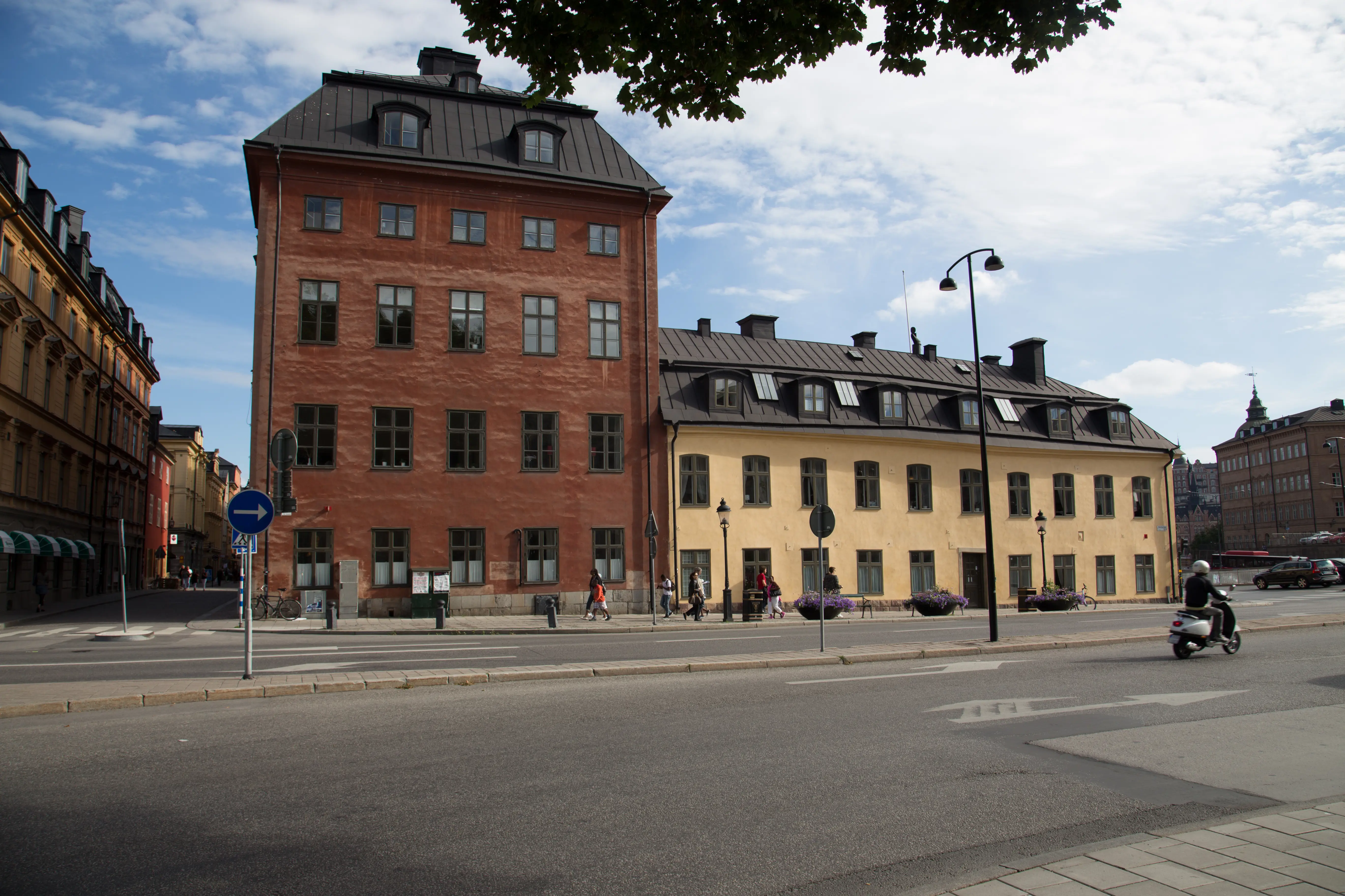 Ryningska palatset. Två sammanbyggda hus, det ena ett rödputsat fyravåningshus, det andra ett gulputsat tvåvåningshus.