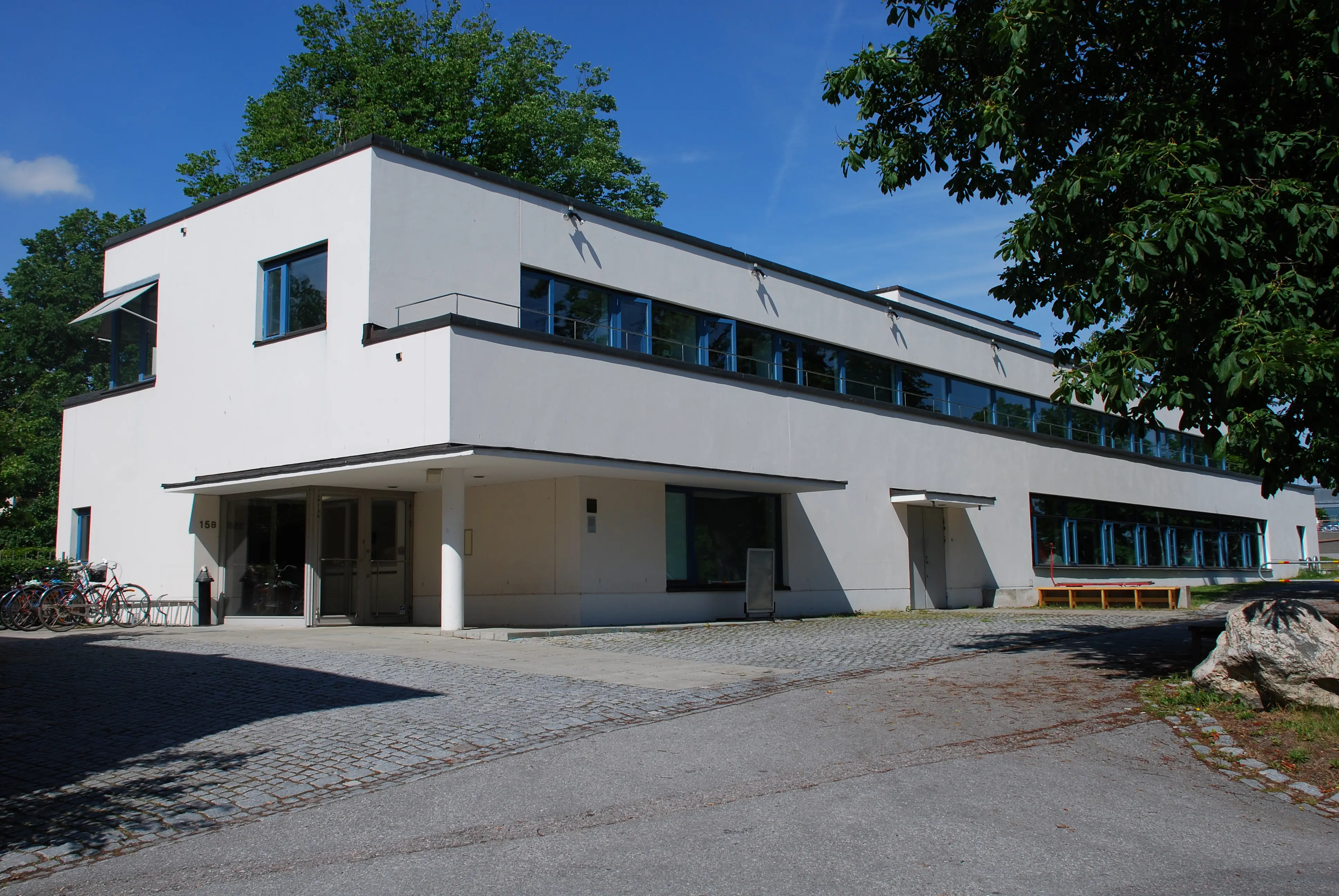 Arkitektur- och design-centrum, flygeln. En vit, modernistisk byggnad. Sommar och grönska.