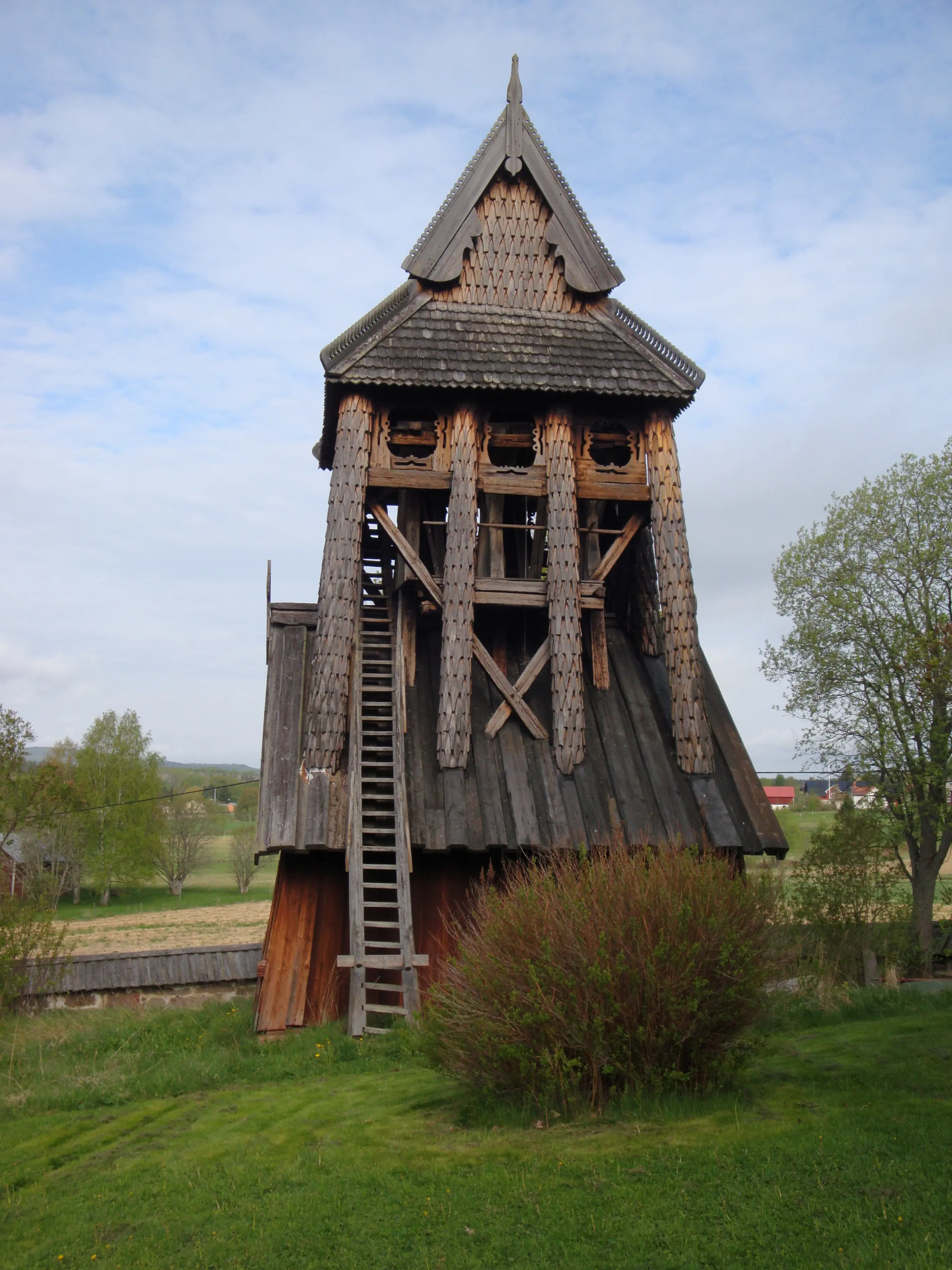 Trönö gamla kyrka. Klocktorn i trä. Tornet är klätt med träspån.
