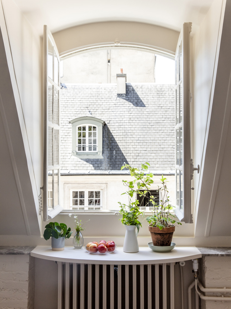 Svenska institutet i Paris. Gästbostad. Utsikt genom ett stort, öppet fönster mot ett hustak med tak-kupa.